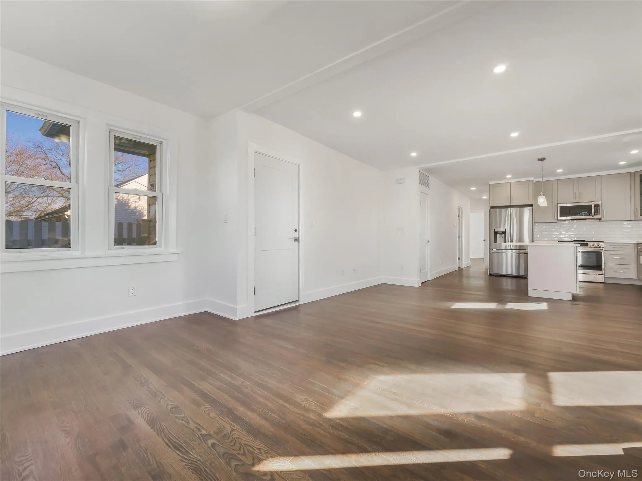 Unfurnished living room featuring dark wood-type flooring Unfurnished living room featuring dark wood-type flooring
