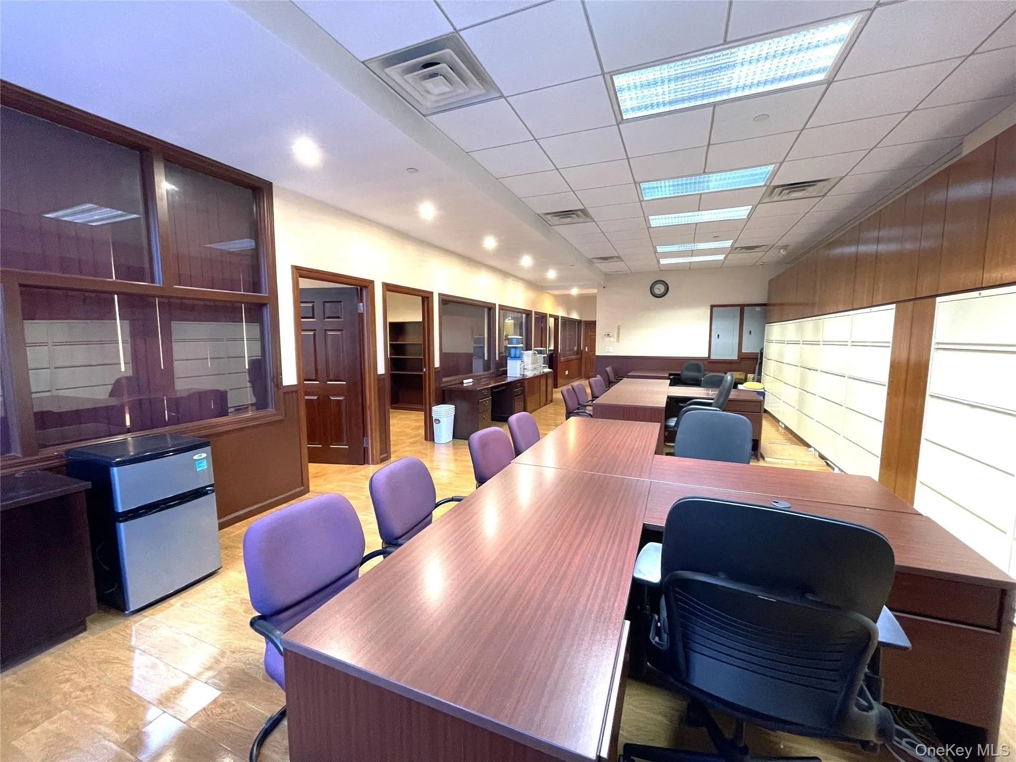Office space with a drop ceiling, wooden walls, and wainscoting Office space with a drop ceiling, wooden walls, and wainscoting