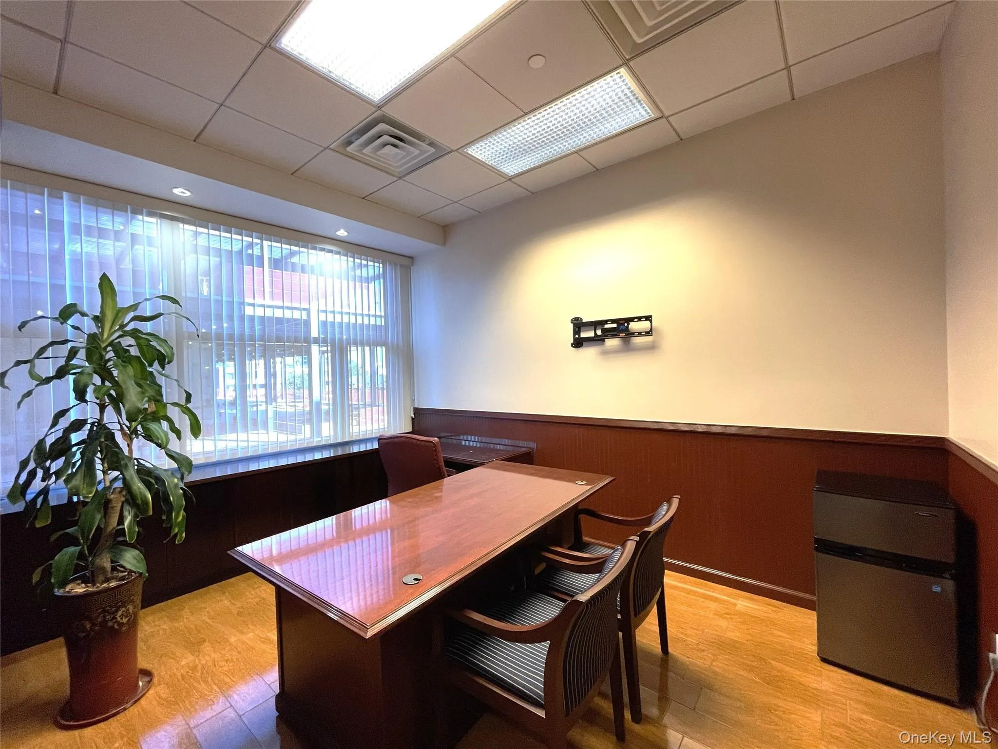 Office featuring wainscoting, a drop ceiling, and wooden walls Office featuring wainscoting, a drop ceiling, and wooden walls
