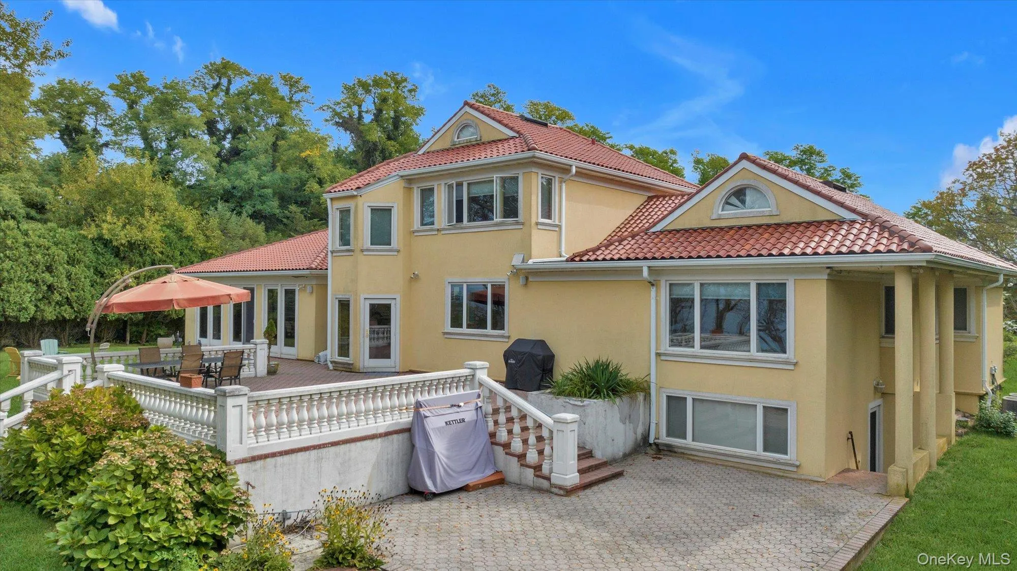 Back of property featuring stucco siding, a wooden deck, outdoor dining area, and a tile roof Back of property featuring stucco siding, a wooden deck, outdoor dining area, and a tile roof