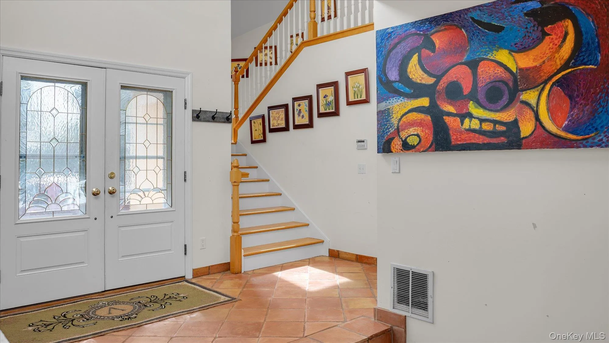 Foyer entrance with tile patterned flooring, french doors, and stairs Foyer entrance with tile patterned flooring, french doors, and stairs