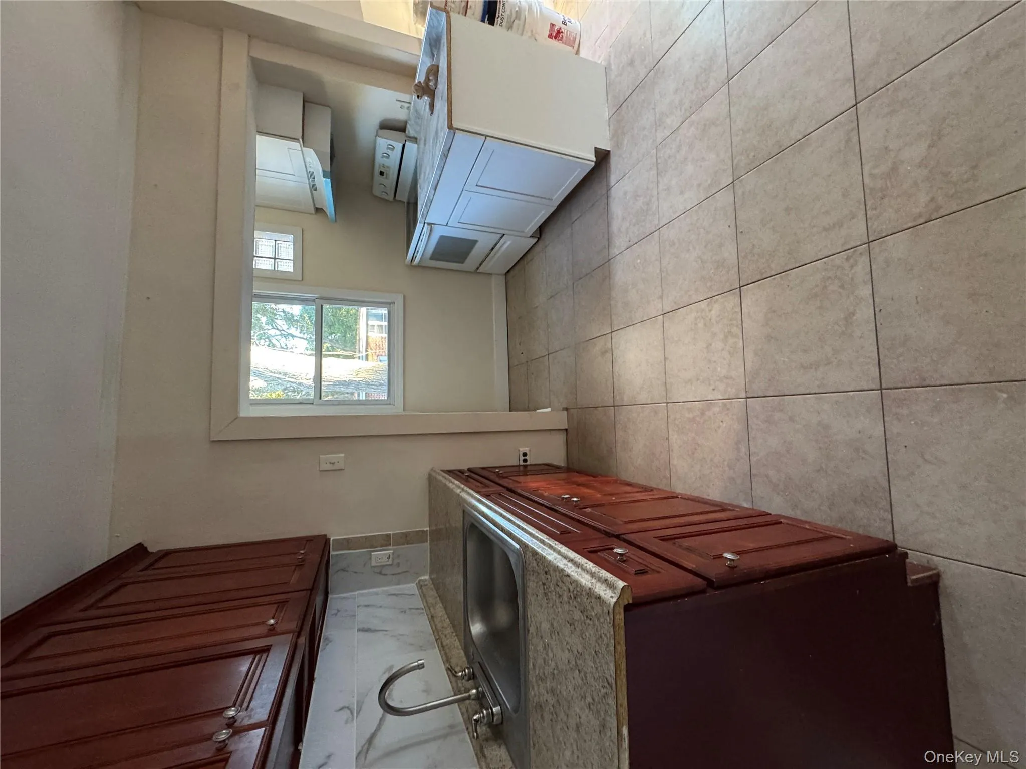 Kitchen with range, light tile patterned floors, light countertops, tasteful backsplash, and extractor fan Kitchen with range, light tile patterned floors, light countertops, tasteful backsplash, and extractor fan