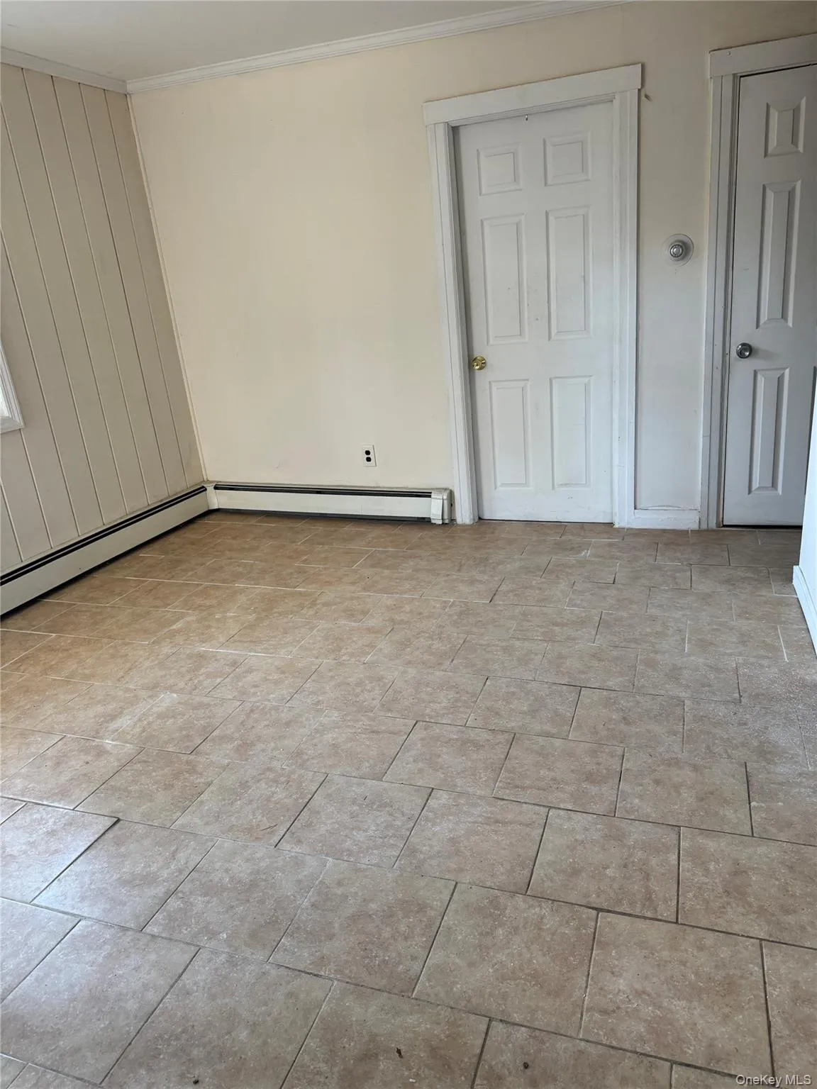 Unfurnished room with a baseboard heating unit and crown molding Unfurnished room with a baseboard heating unit and crown molding