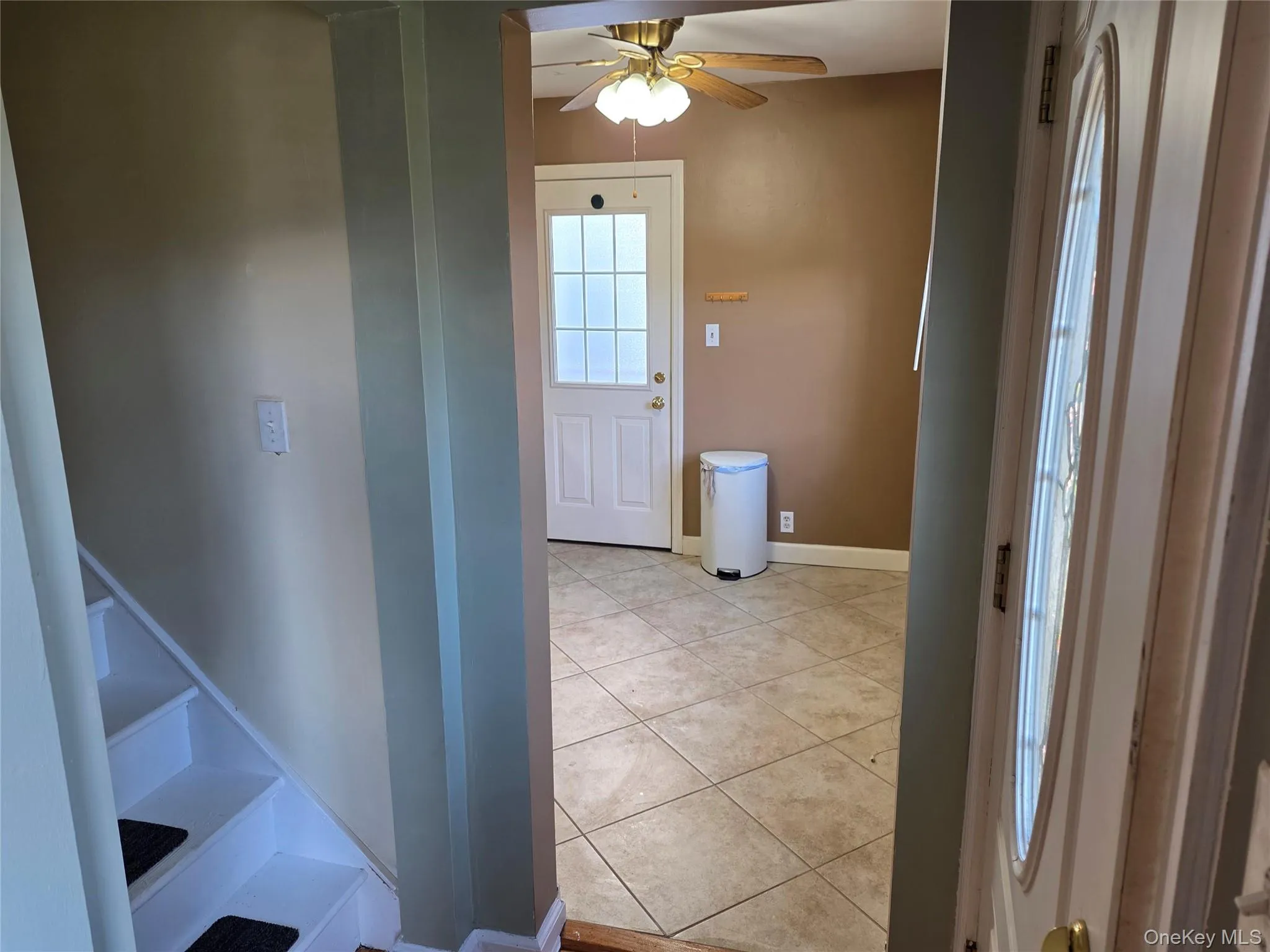 Hall featuring light tile patterned floors and baseboards Hall featuring light tile patterned floors and baseboards