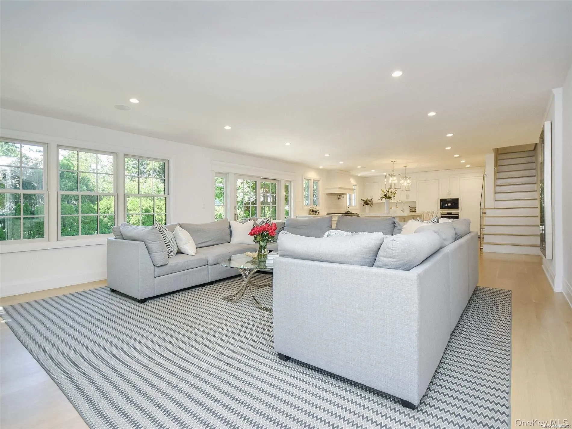 Living area with light wood-style flooring, recessed lighting, stairs, and a chandelier Living area with light wood-style flooring, recessed lighting, stairs, and a chandelier
