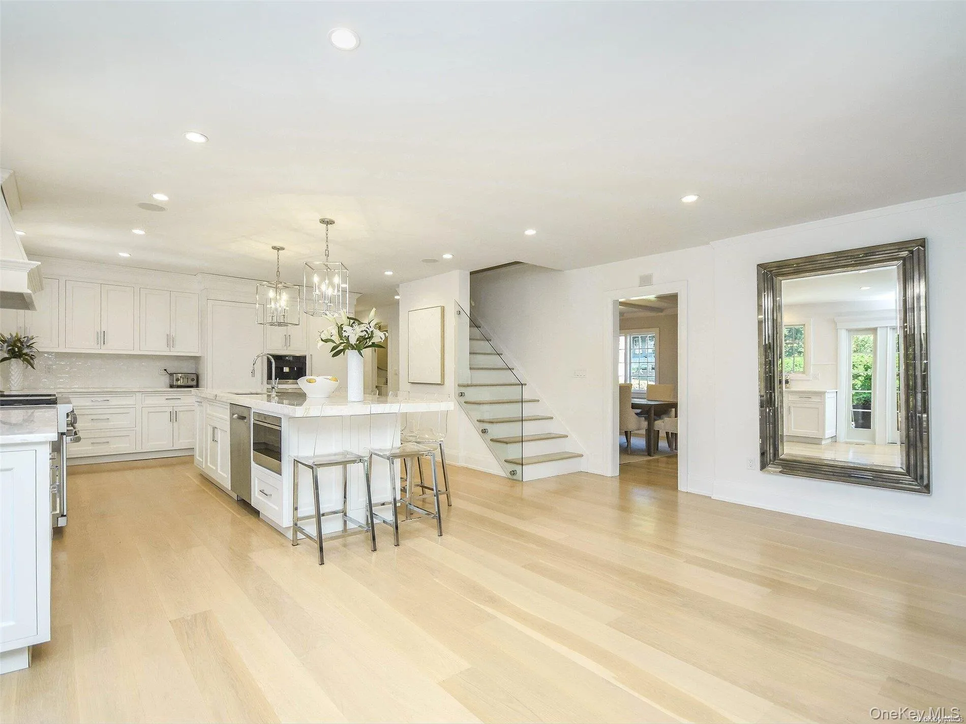 Kitchen with white cabinets, pendant lighting, light wood-type flooring, a kitchen bar, and recessed lighting Kitchen with white cabinets, pendant lighting, light wood-type flooring, a kitchen bar, and recessed lighting