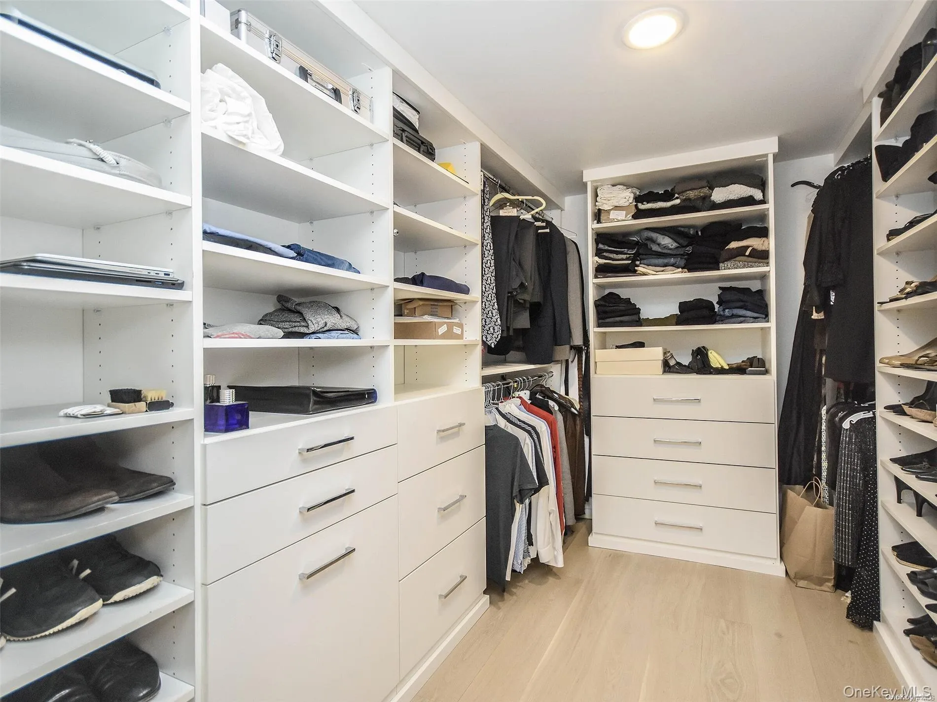 Walk in closet featuring light wood-style floors Walk in closet featuring light wood-style floors