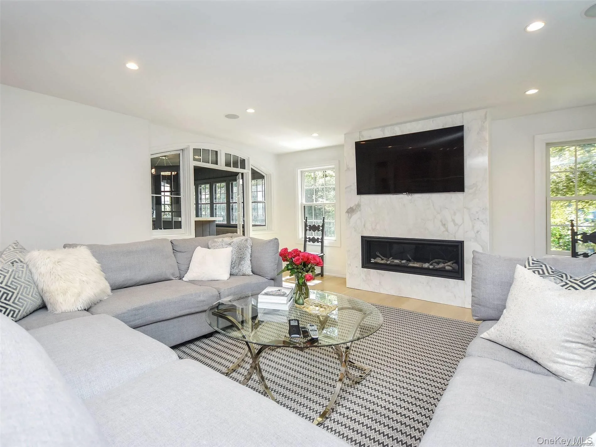 Living area featuring recessed lighting, a high end fireplace, and wood finished floors Living area featuring recessed lighting, a high end fireplace, and wood finished floors