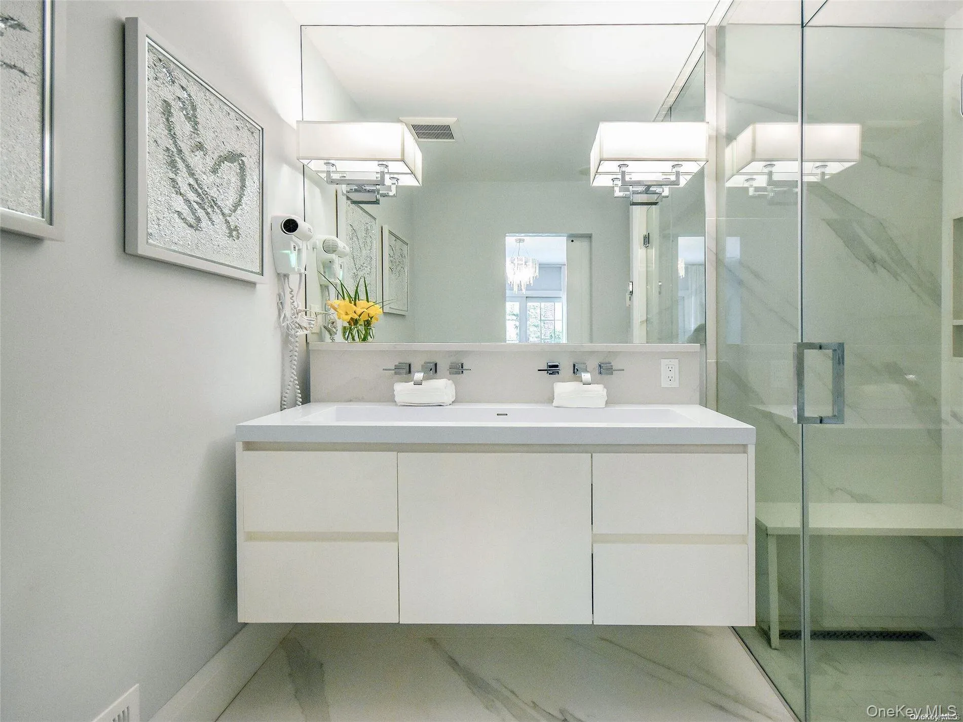Bathroom with a marble finish shower, vanity, and light marble finish floors Bathroom with a marble finish shower, vanity, and light marble finish floors