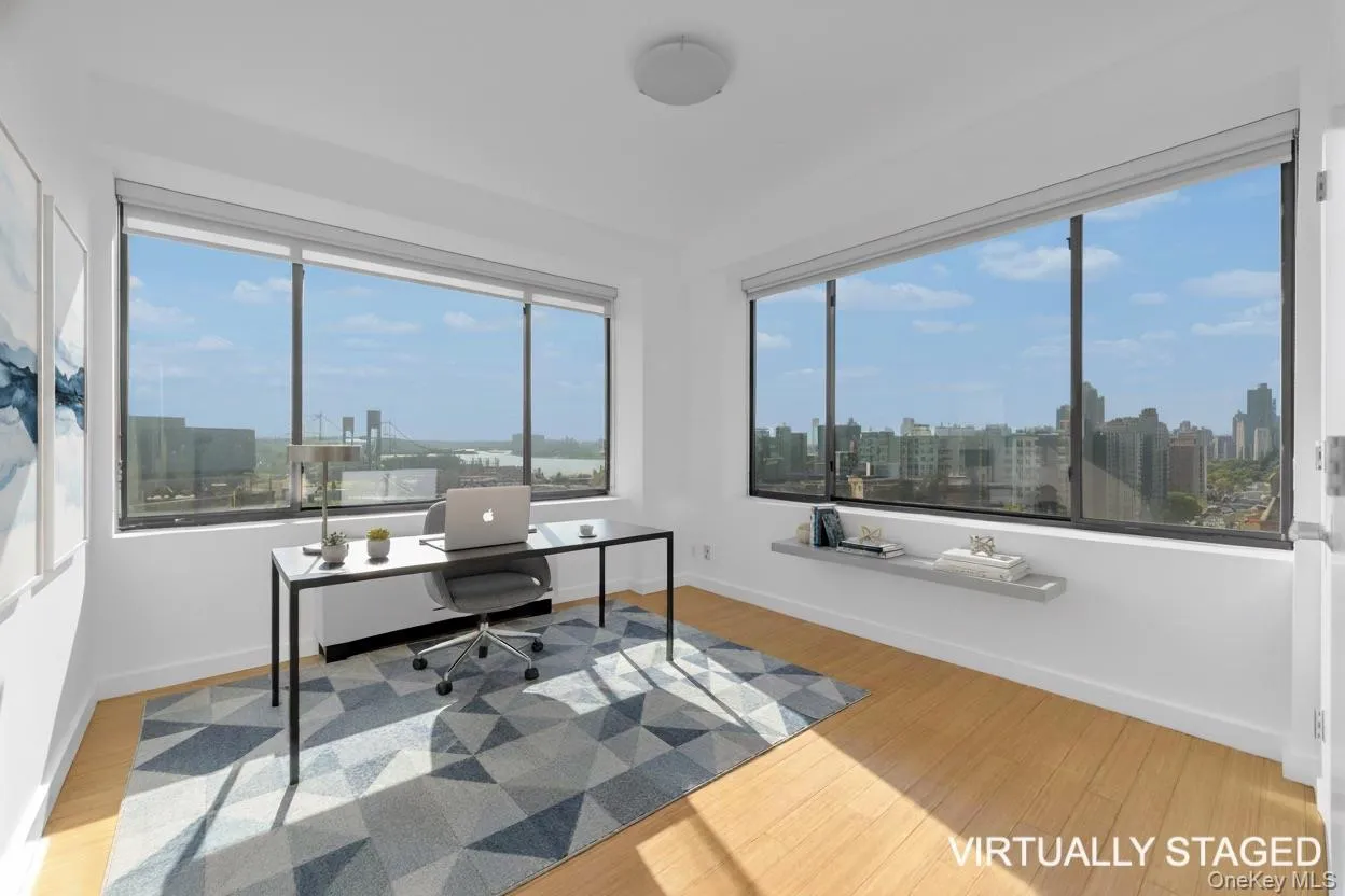 Office space featuring light wood finished floors, plenty of natural light, and a skyline view Office space featuring light wood finished floors, plenty of natural light, and a skyline view