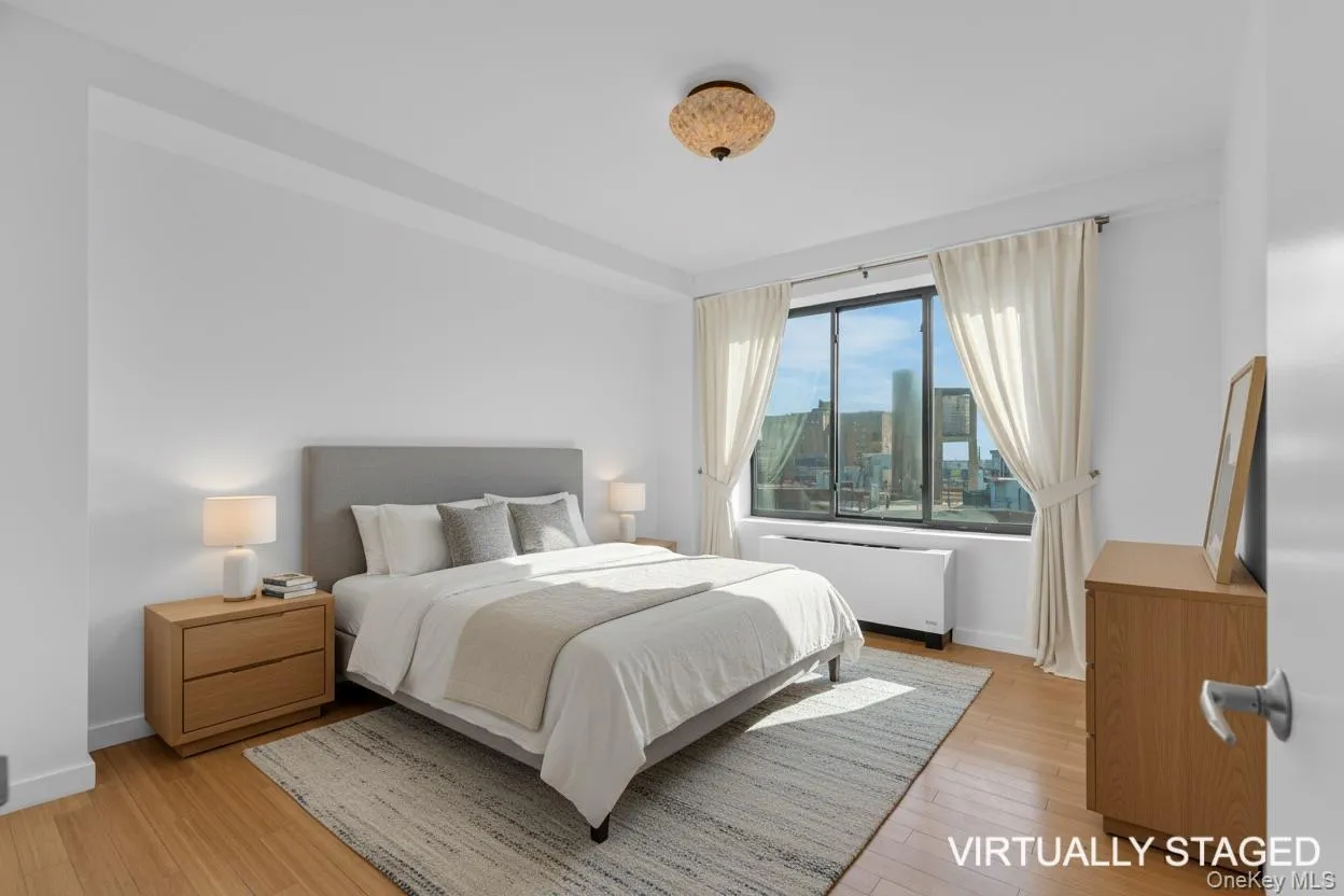 Bedroom featuring light wood-style flooring and radiator Bedroom featuring light wood-style flooring and radiator