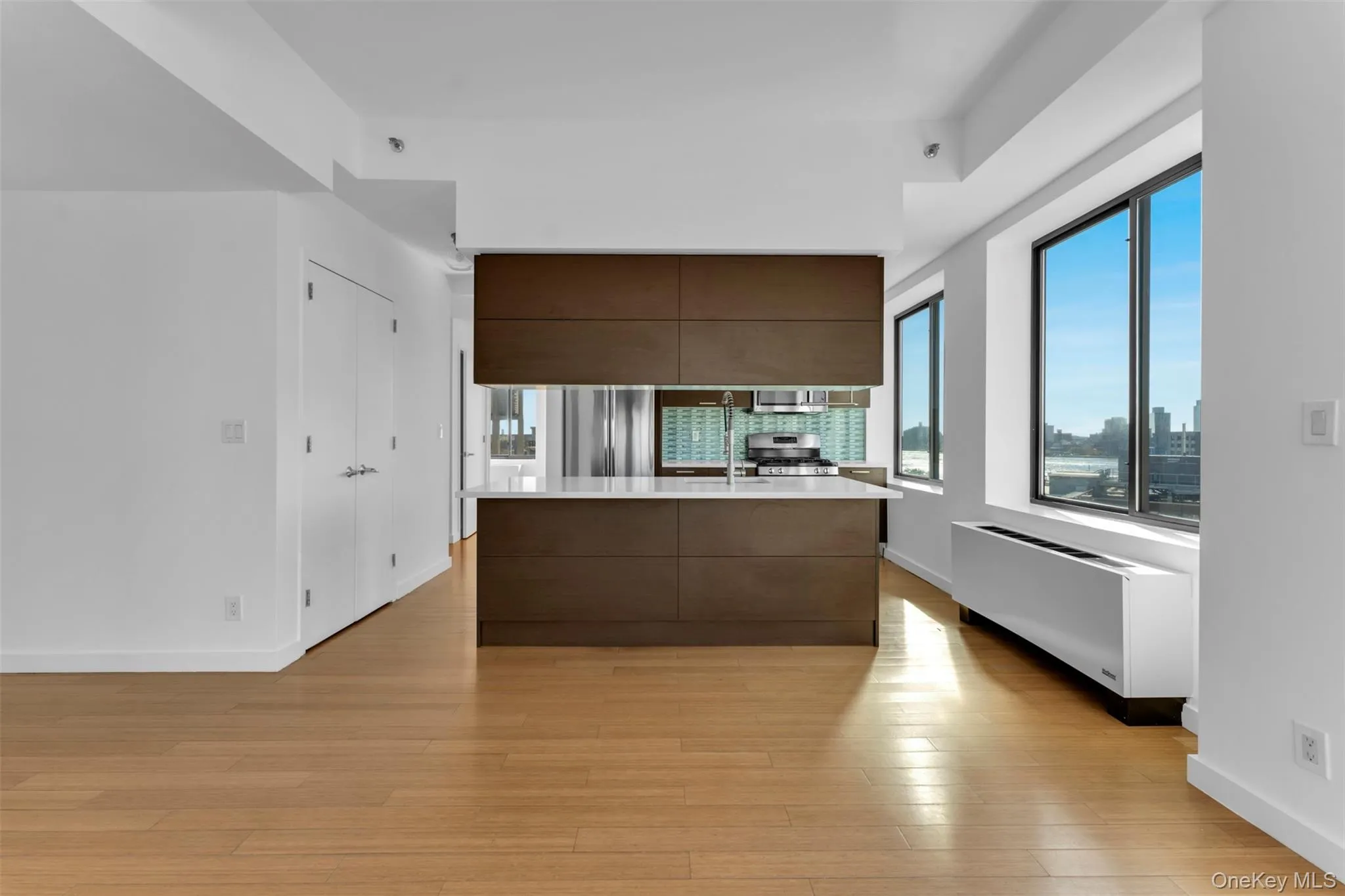 Kitchen with modern cabinets, healthy amount of natural light, radiator heating unit, and dark brown cabinetry Kitchen with modern cabinets, healthy amount of natural light, radiator heating unit, and dark brown cabinetry
