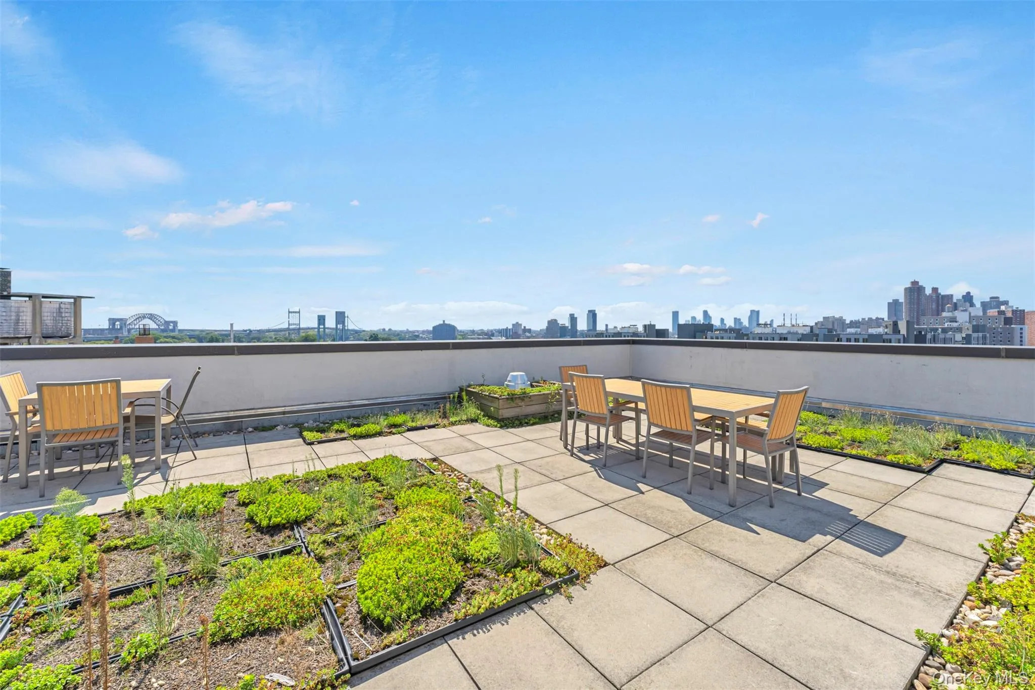 View of roo deck featuring outdoor dining area, a view of skyline, and a garden View of roo deck featuring outdoor dining area, a view of skyline, and a garden
