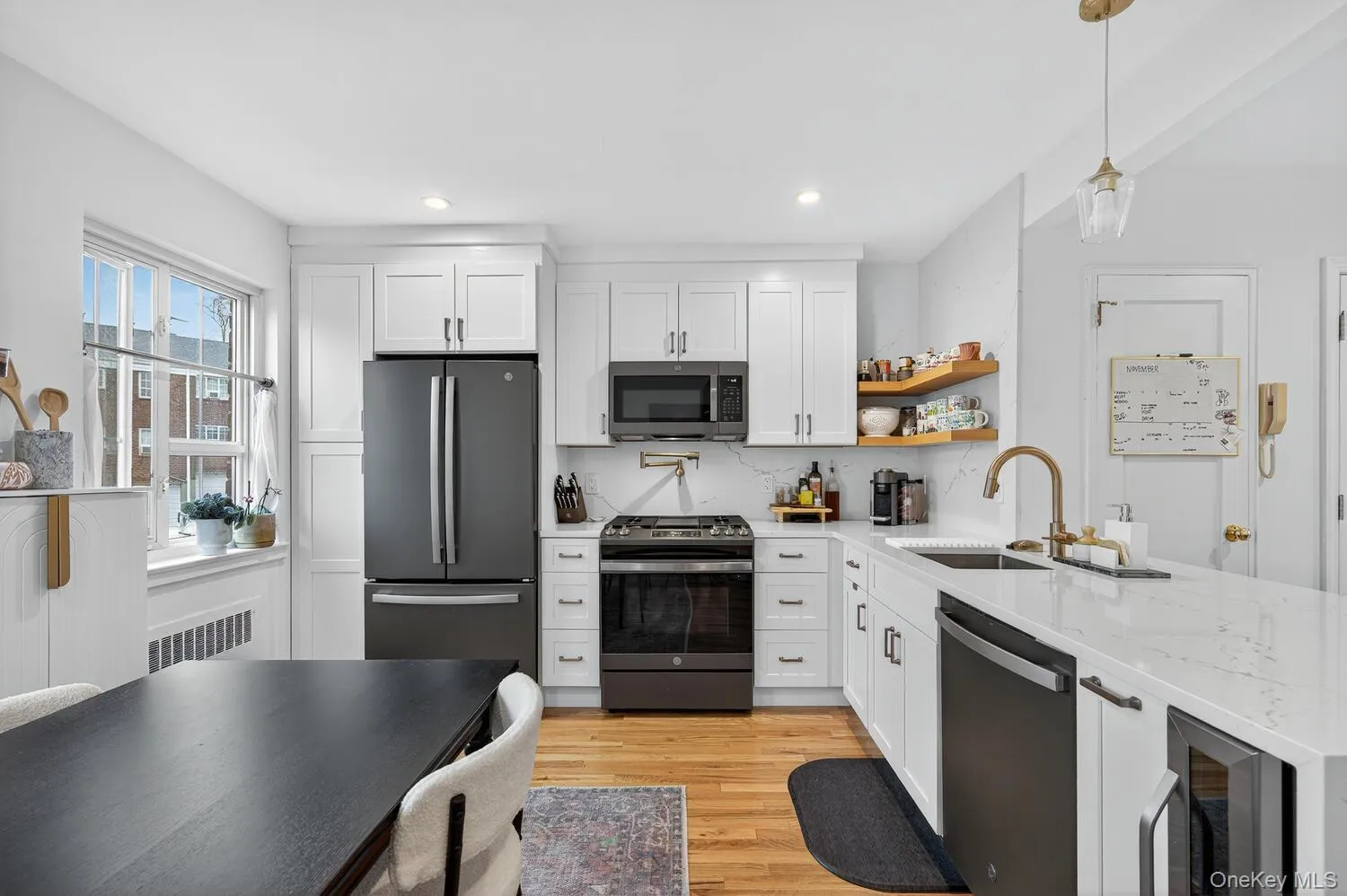 Kitchen with light stone countertops, white cabinets, stainless steel appliances, and recessed lighting Kitchen with light stone countertops, white cabinets, stainless steel appliances, and recessed lighting