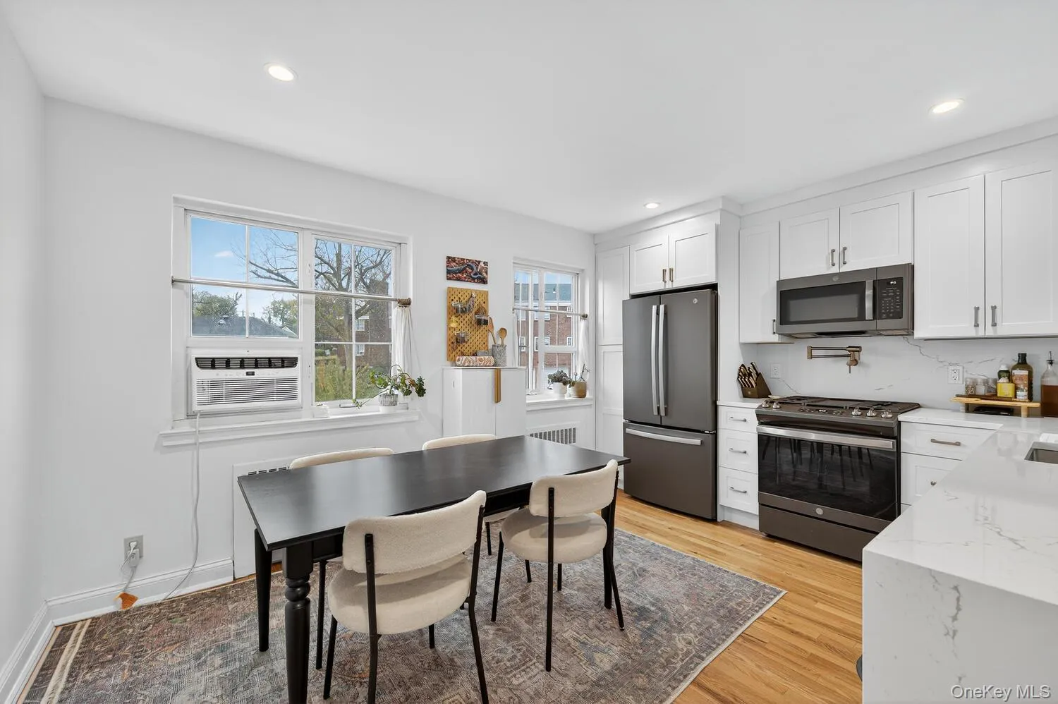 Kitchen featuring stainless steel appliances, light stone counters, white cabinets, light wood-type flooring, and recessed lighting Kitchen featuring stainless steel appliances, light stone counters, white cabinets, light wood-type flooring, and recessed lighting