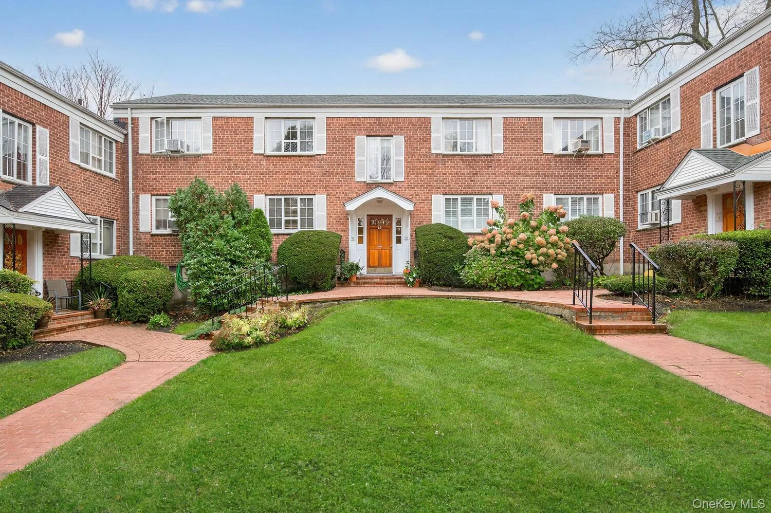 Colonial house featuring a front lawn and brick siding Colonial house featuring a front lawn and brick siding