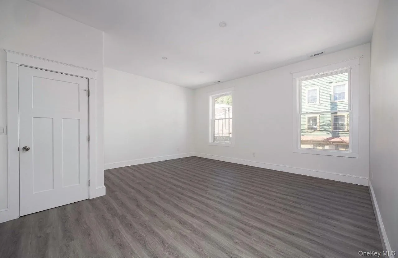 Unfurnished room featuring dark wood-style floors and baseboards Unfurnished room featuring dark wood-style floors and baseboards