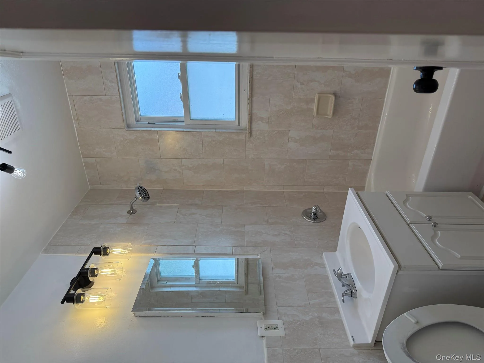 Full bath featuring bathing tub / shower combination, vanity, and tile walls Full bath featuring bathing tub / shower combination, vanity, and tile walls