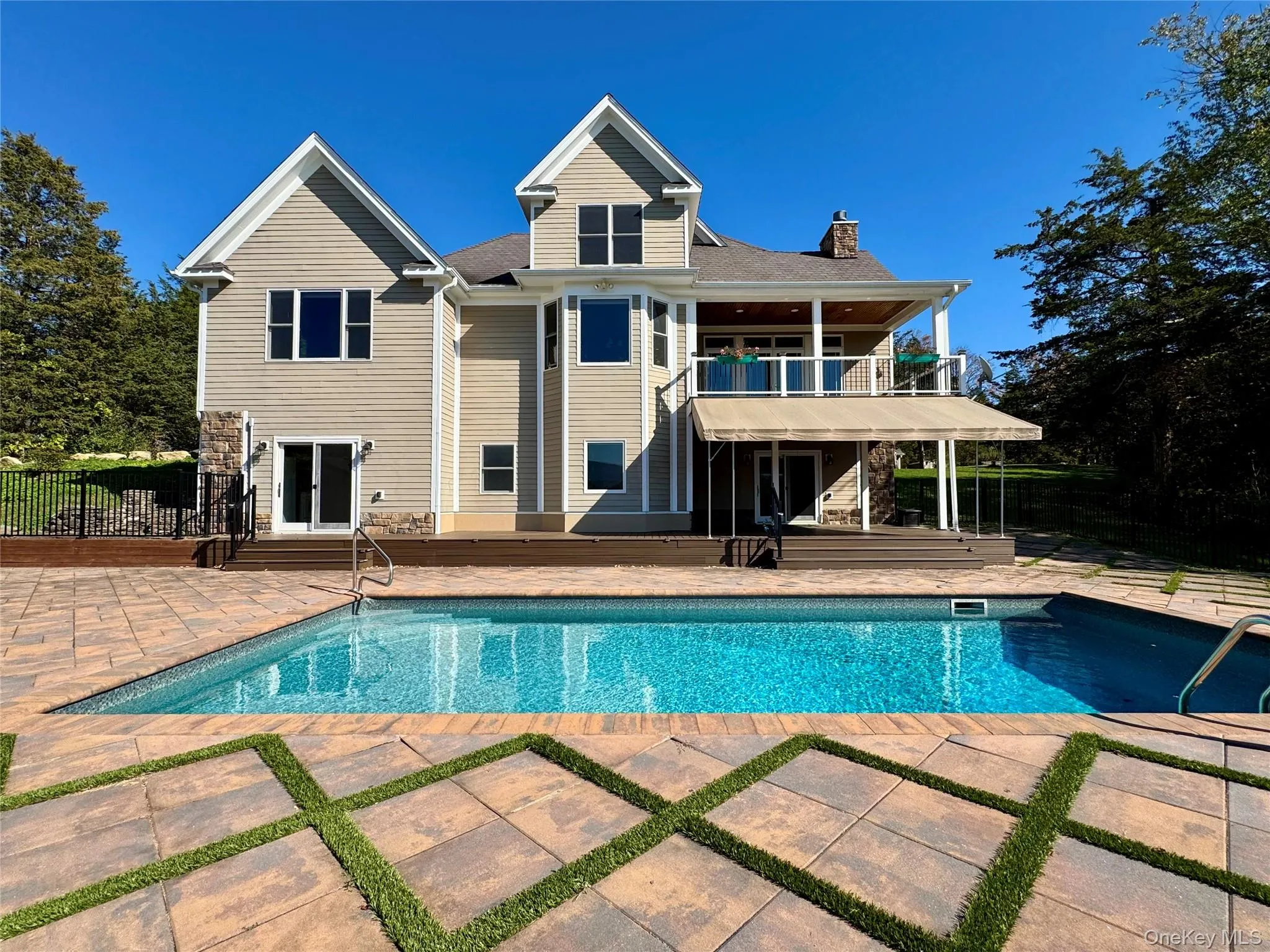 Rear view of property with a patio area, a chimney, a balcony, and stairs Rear view of property with a patio area, a chimney, a balcony, and stairs