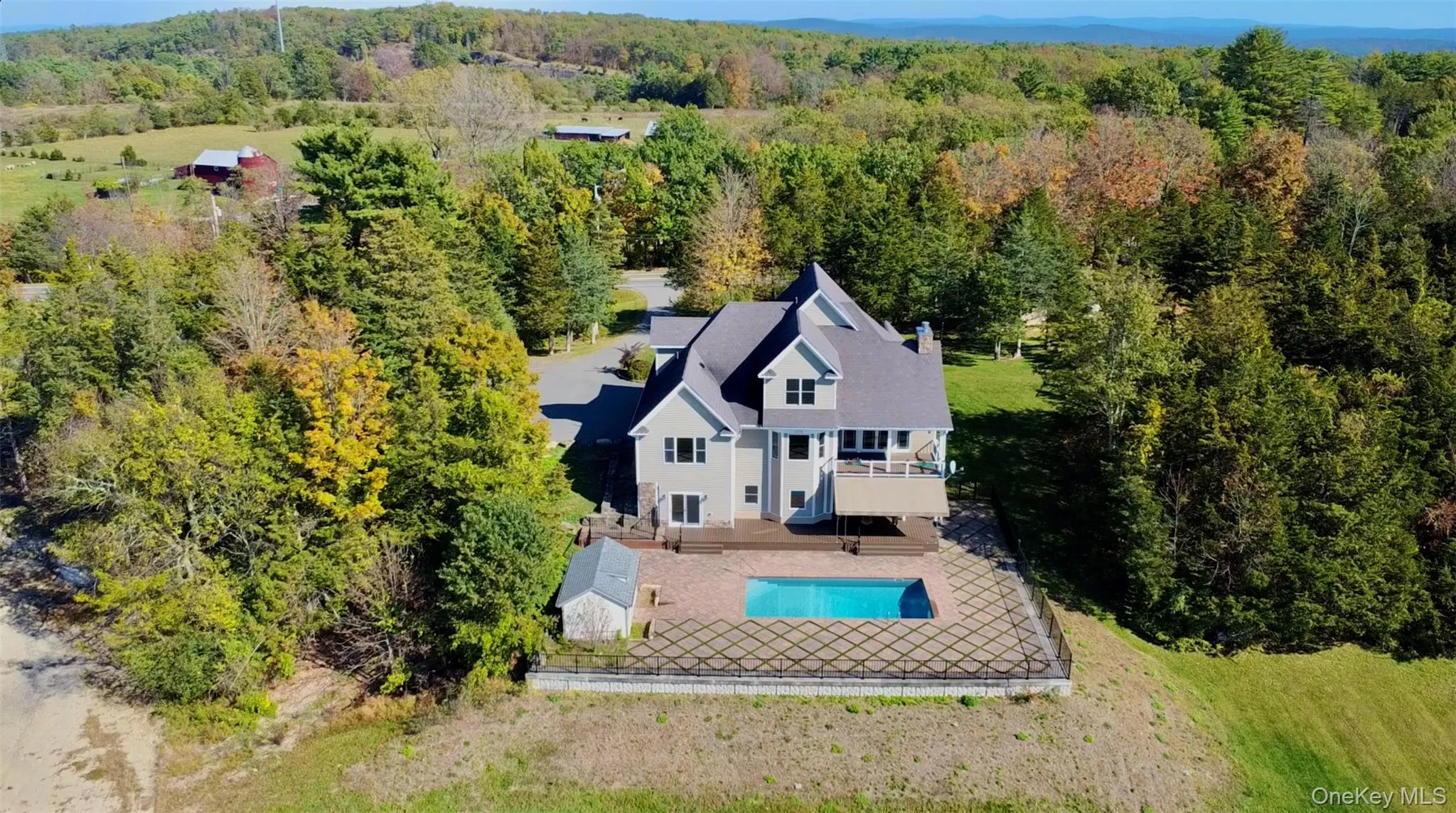 View of subject property featuring a pool and a forest View of subject property featuring a pool and a forest