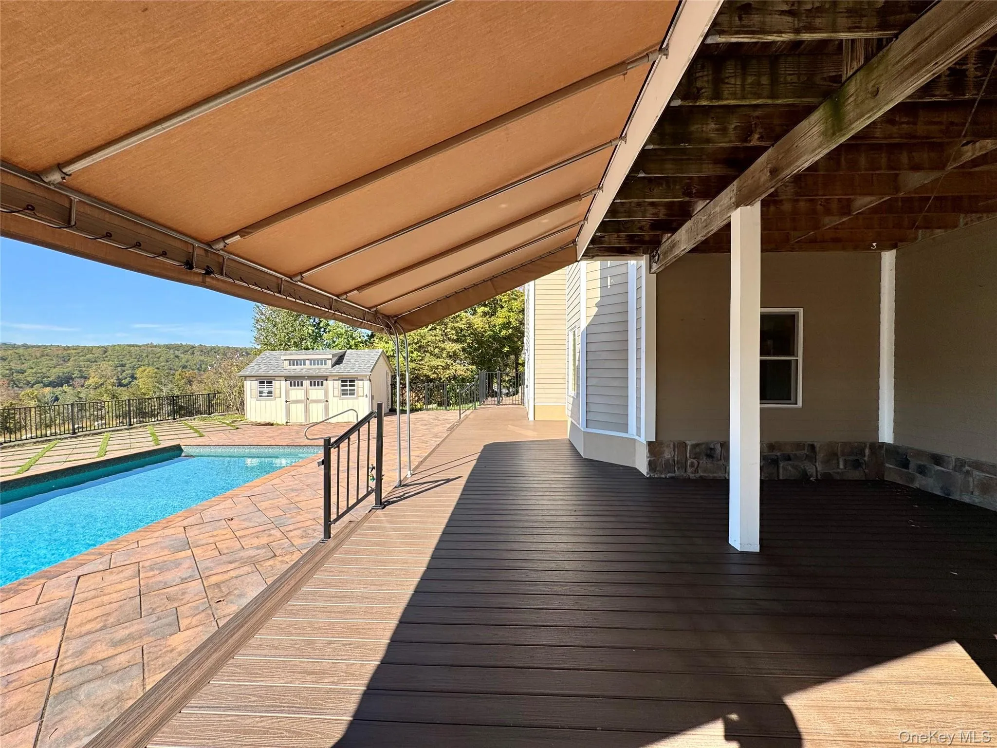 Wooden terrace featuring a storage unit and a patio area Wooden terrace featuring a storage unit and a patio area