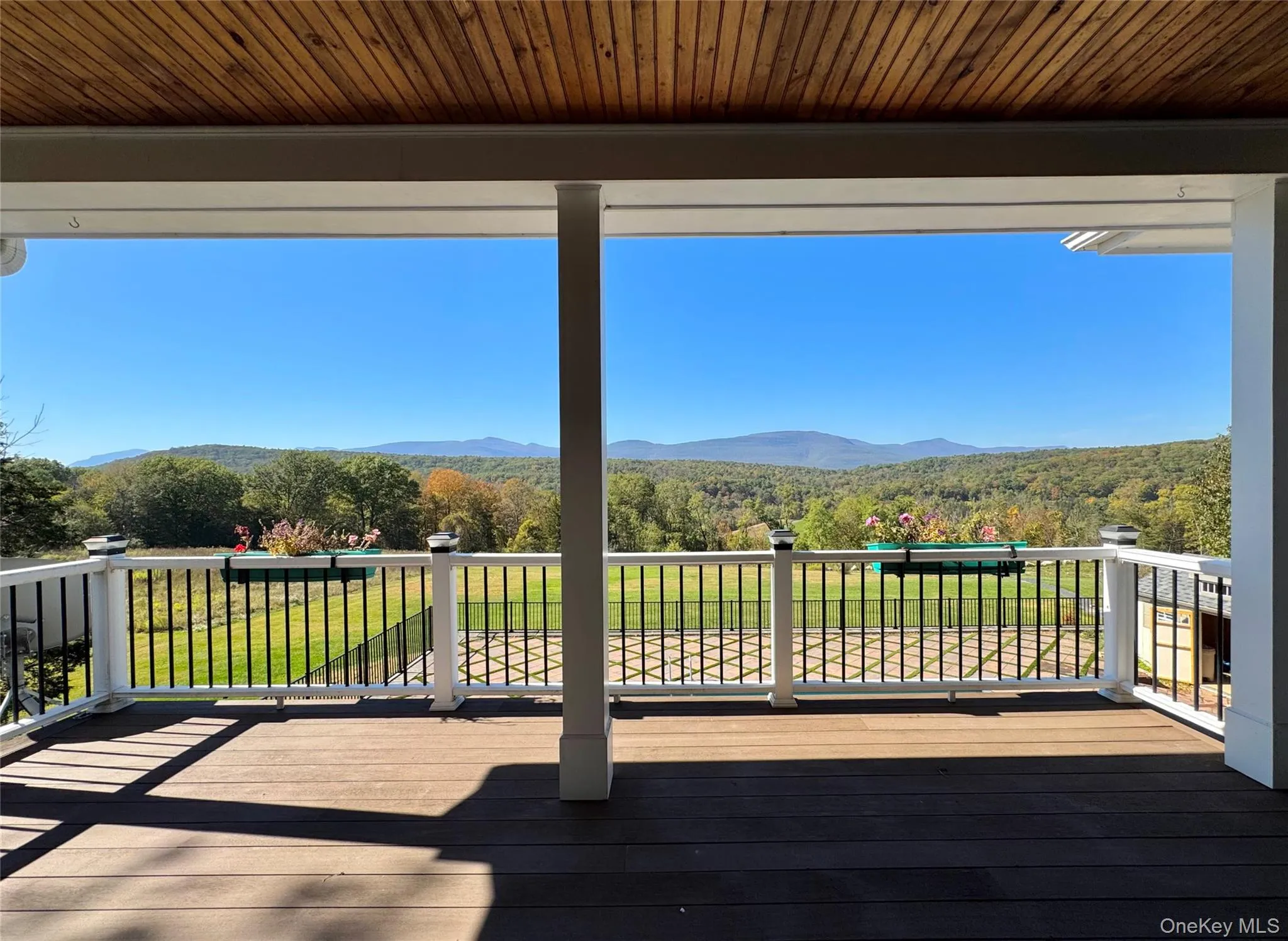 Wooden terrace featuring a wooded view and a mountain view Wooden terrace featuring a wooded view and a mountain view
