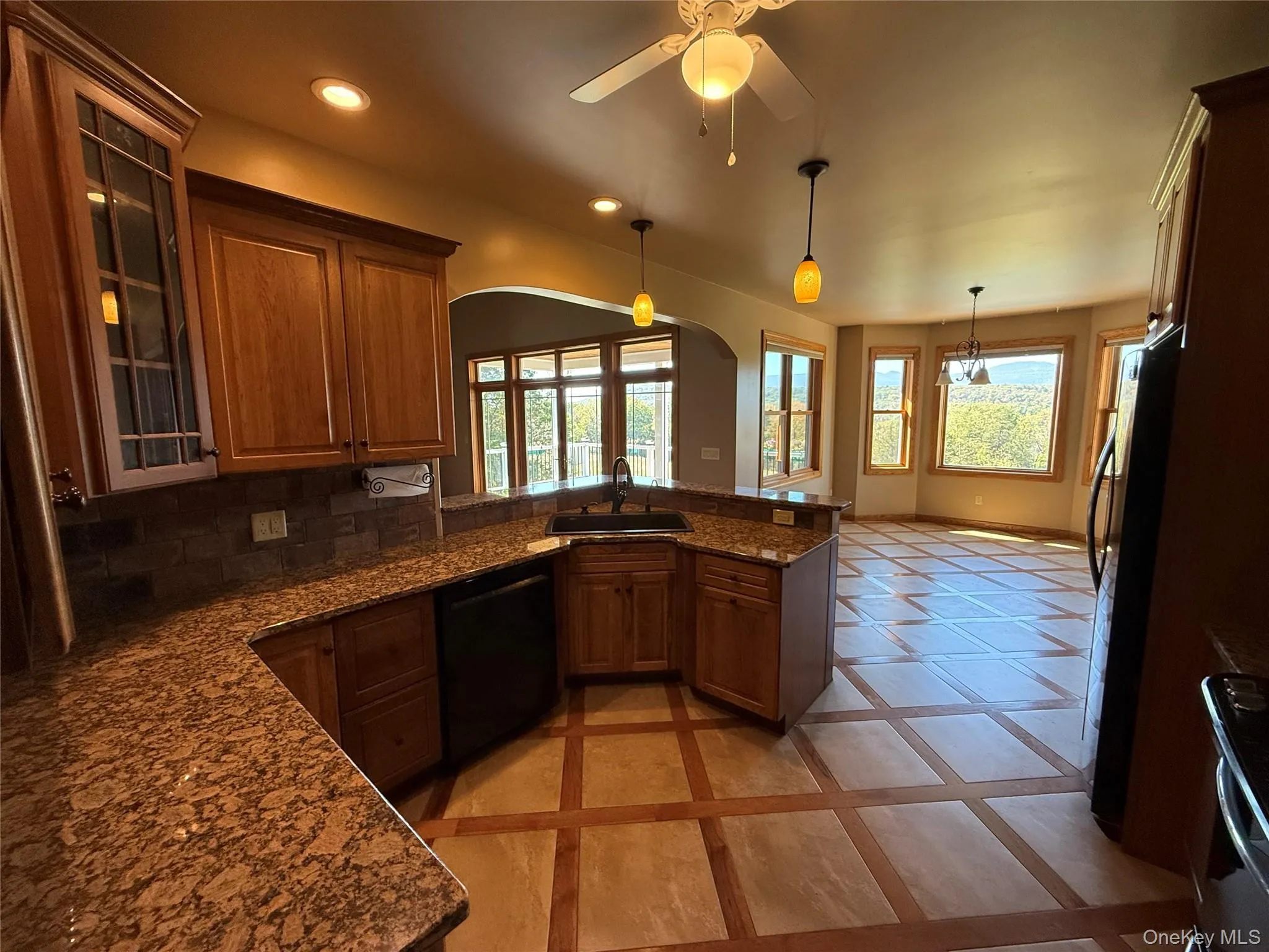 Kitchen with inlaid floor details, glass insert cabinets, pendant lighting, recessed lighting, and appliances with stainless steel finishes Kitchen with inlaid floor details, glass insert cabinets, pendant lighting, recessed lighting, and appliances with stainless steel finishes
