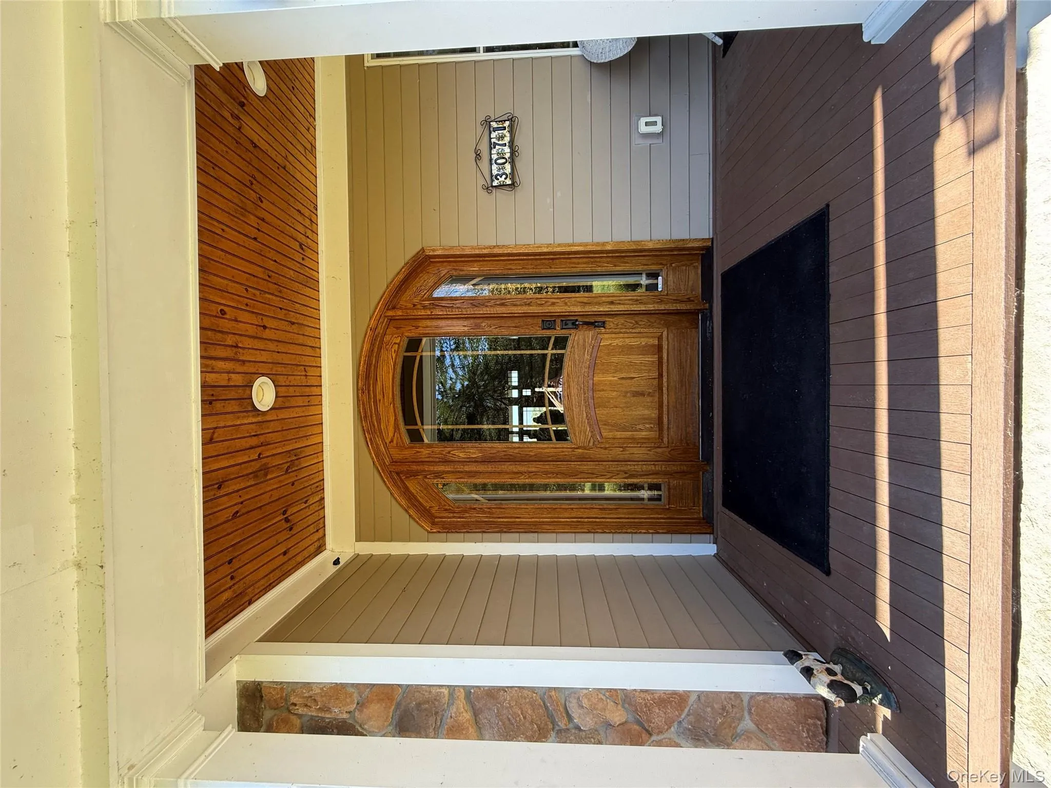 Property entrance featuring a deck and stone siding Property entrance featuring a deck and stone siding