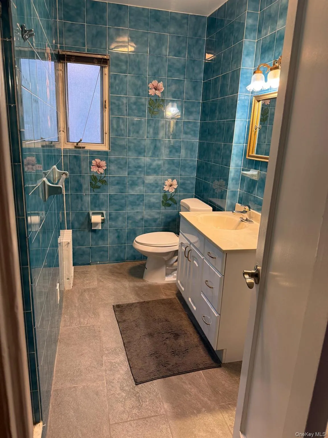 Bathroom with tile walls, vanity, and tile patterned floors Bathroom with tile walls, vanity, and tile patterned floors
