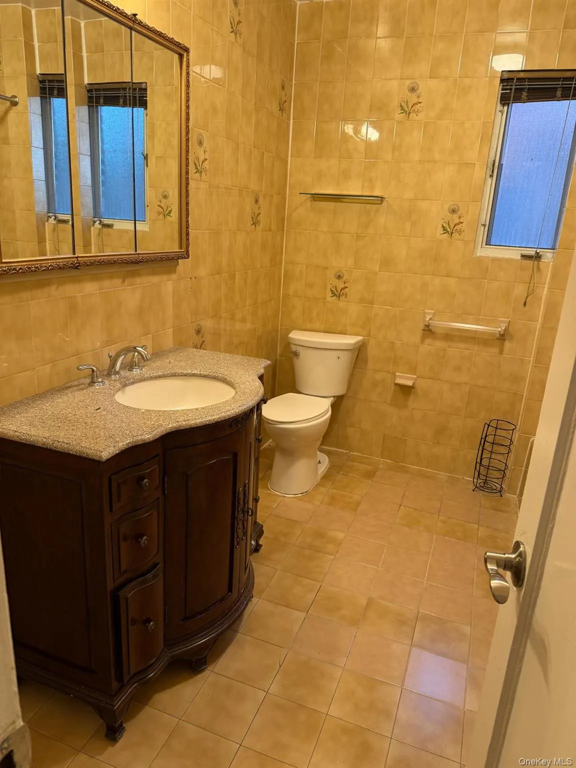 Bathroom featuring tile walls, light tile patterned floors, and vanity Bathroom featuring tile walls, light tile patterned floors, and vanity
