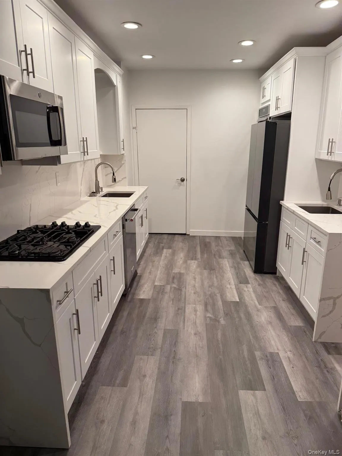 Kitchen featuring light stone counters, appliances with stainless steel finishes, decorative backsplash, white cabinets, and recessed lighting Kitchen featuring light stone counters, appliances with stainless steel finishes, decorative backsplash, white cabinets, and recessed lighting
