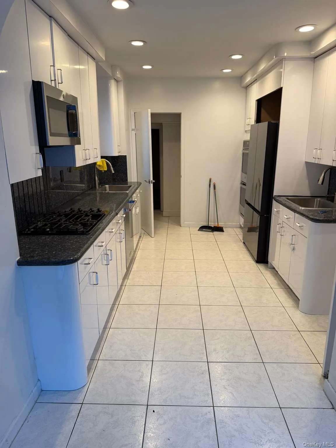 Kitchen with dark stone countertops, white cabinets, tasteful backsplash, recessed lighting, and stainless steel appliances Kitchen with dark stone countertops, white cabinets, tasteful backsplash, recessed lighting, and stainless steel appliances