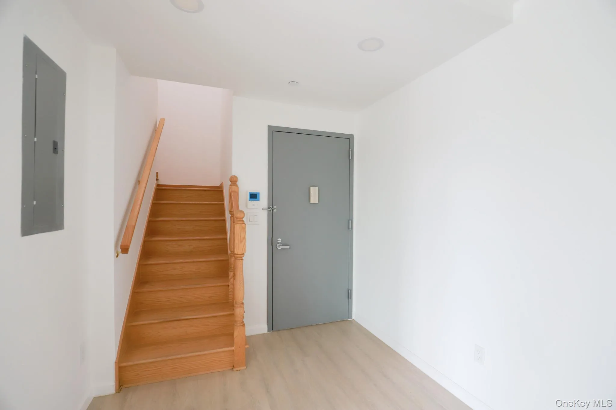 Stairs featuring wood finished floors, electric panel, and recessed lighting Stairs featuring wood finished floors, electric panel, and recessed lighting