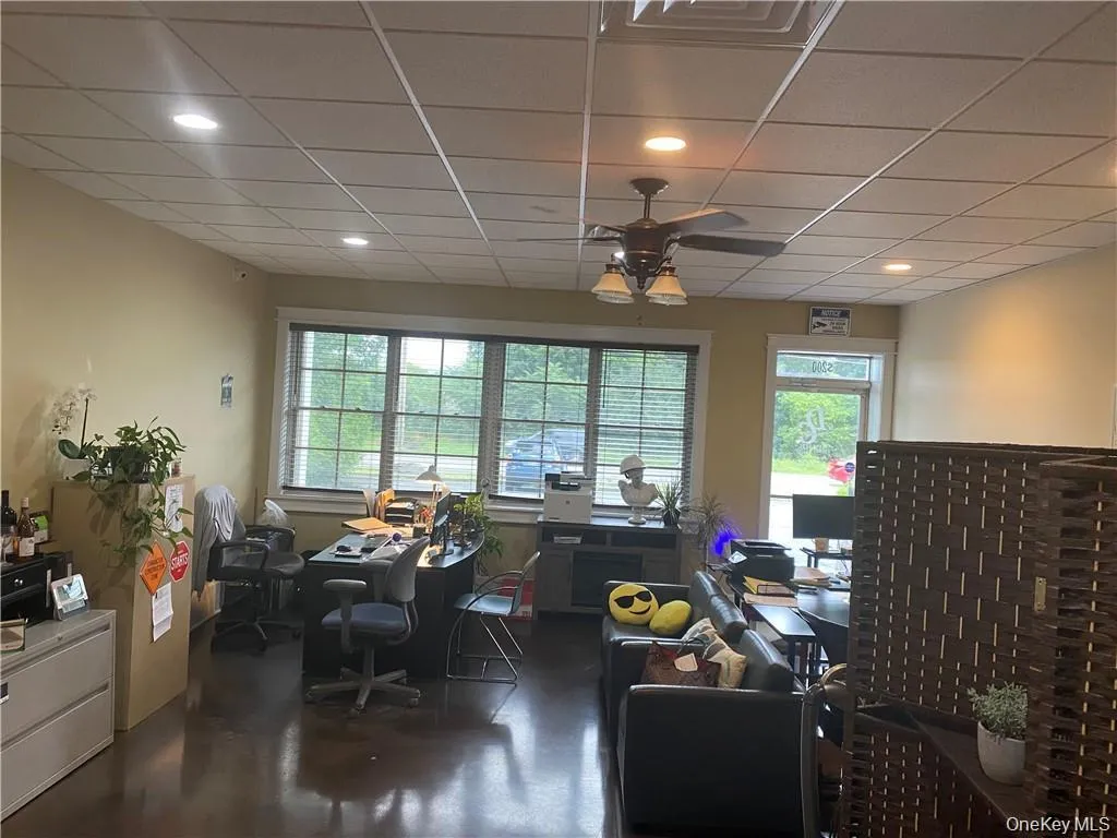 Office with plenty of natural light, a ceiling fan, a paneled ceiling, recessed lighting, and concrete floors Office with plenty of natural light, a ceiling fan, a paneled ceiling, recessed lighting, and concrete floors