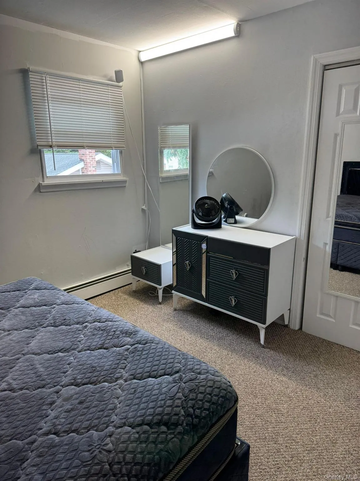 Carpeted bedroom featuring baseboard heating Carpeted bedroom featuring baseboard heating