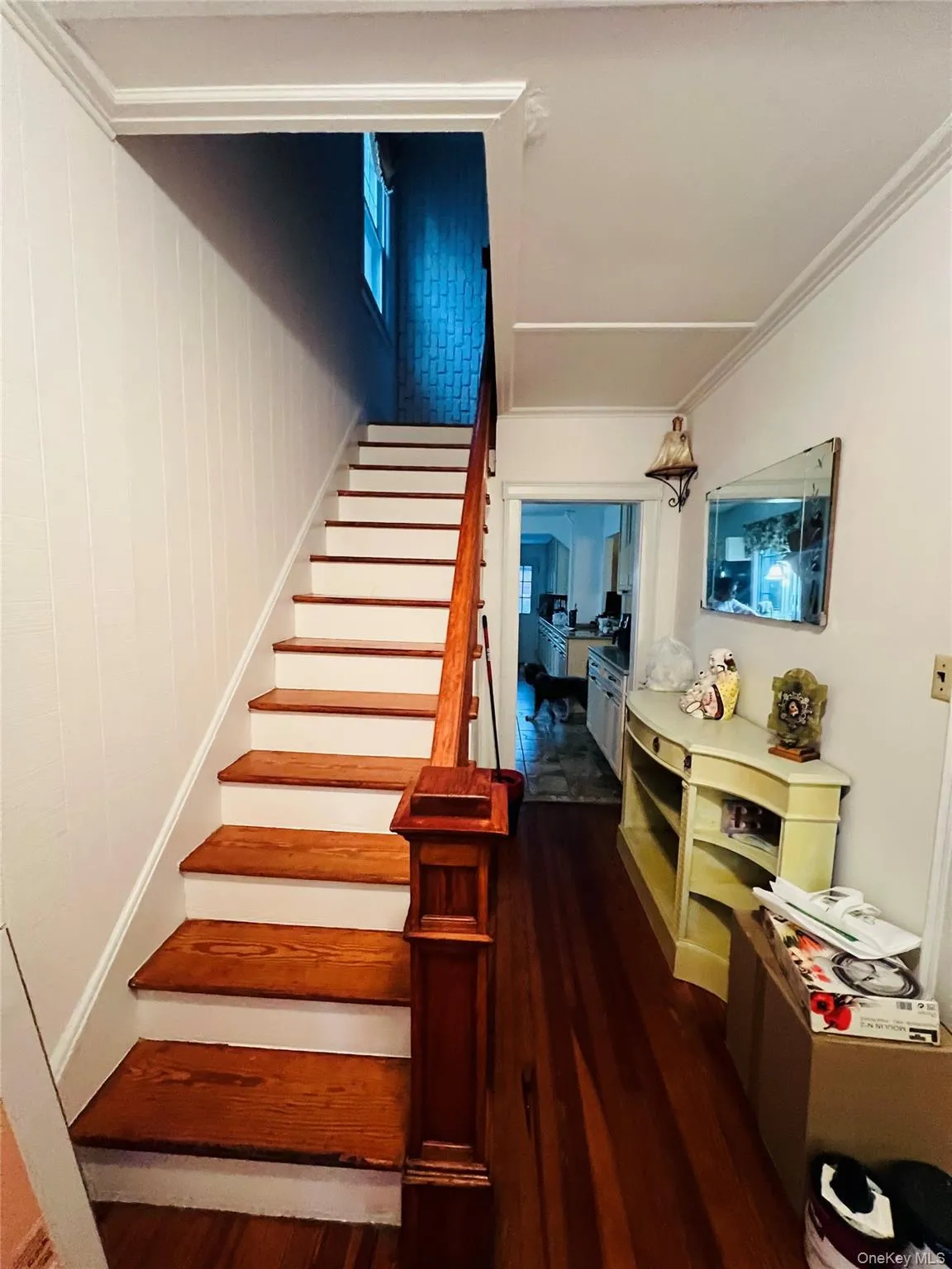 Stairway featuring wood finished floors and crown molding Stairway featuring wood finished floors and crown molding