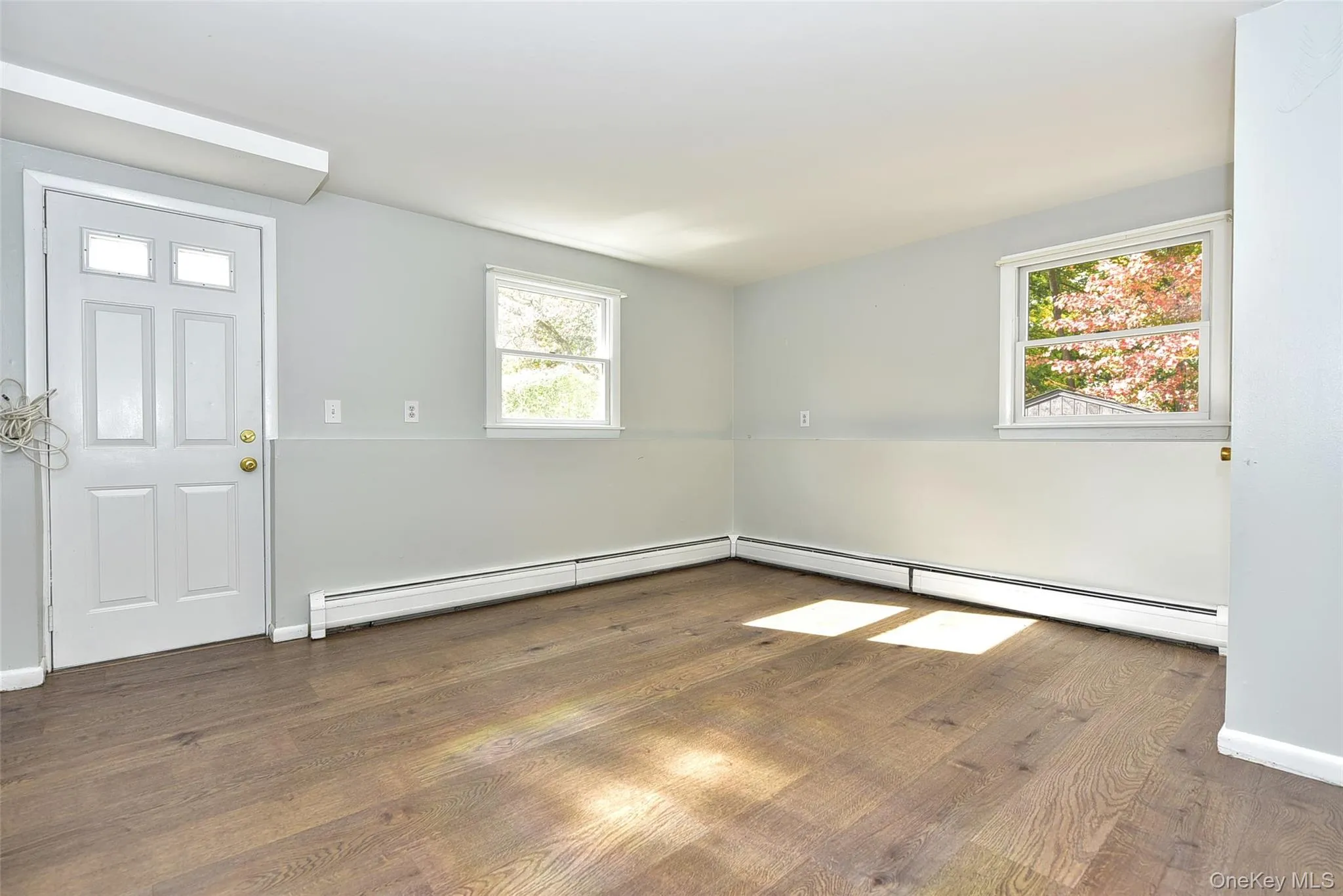 Entryway with baseboard heating and dark wood-style floors Entryway with baseboard heating and dark wood-style floors