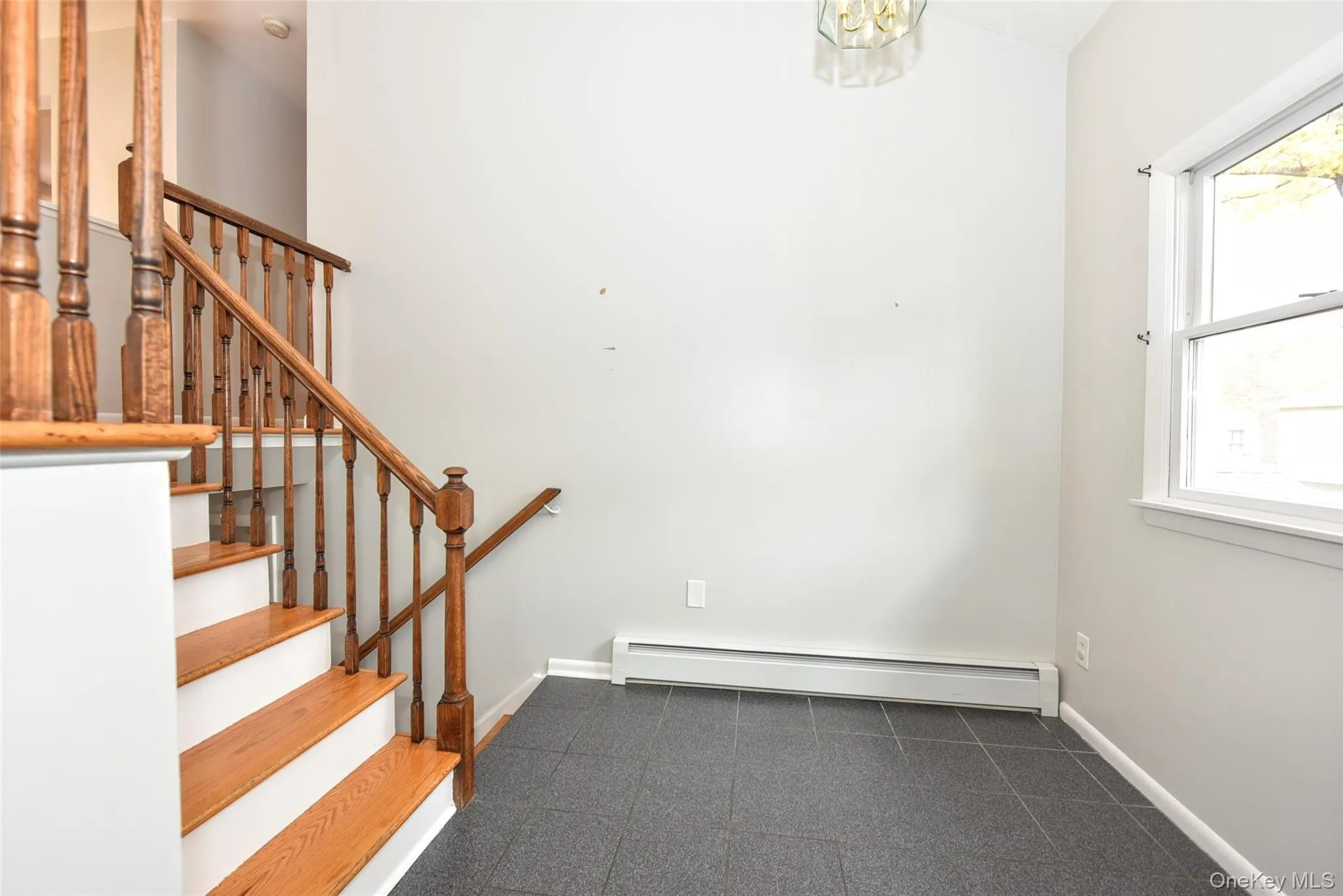 Stairway featuring a baseboard heating unit and baseboards Stairway featuring a baseboard heating unit and baseboards