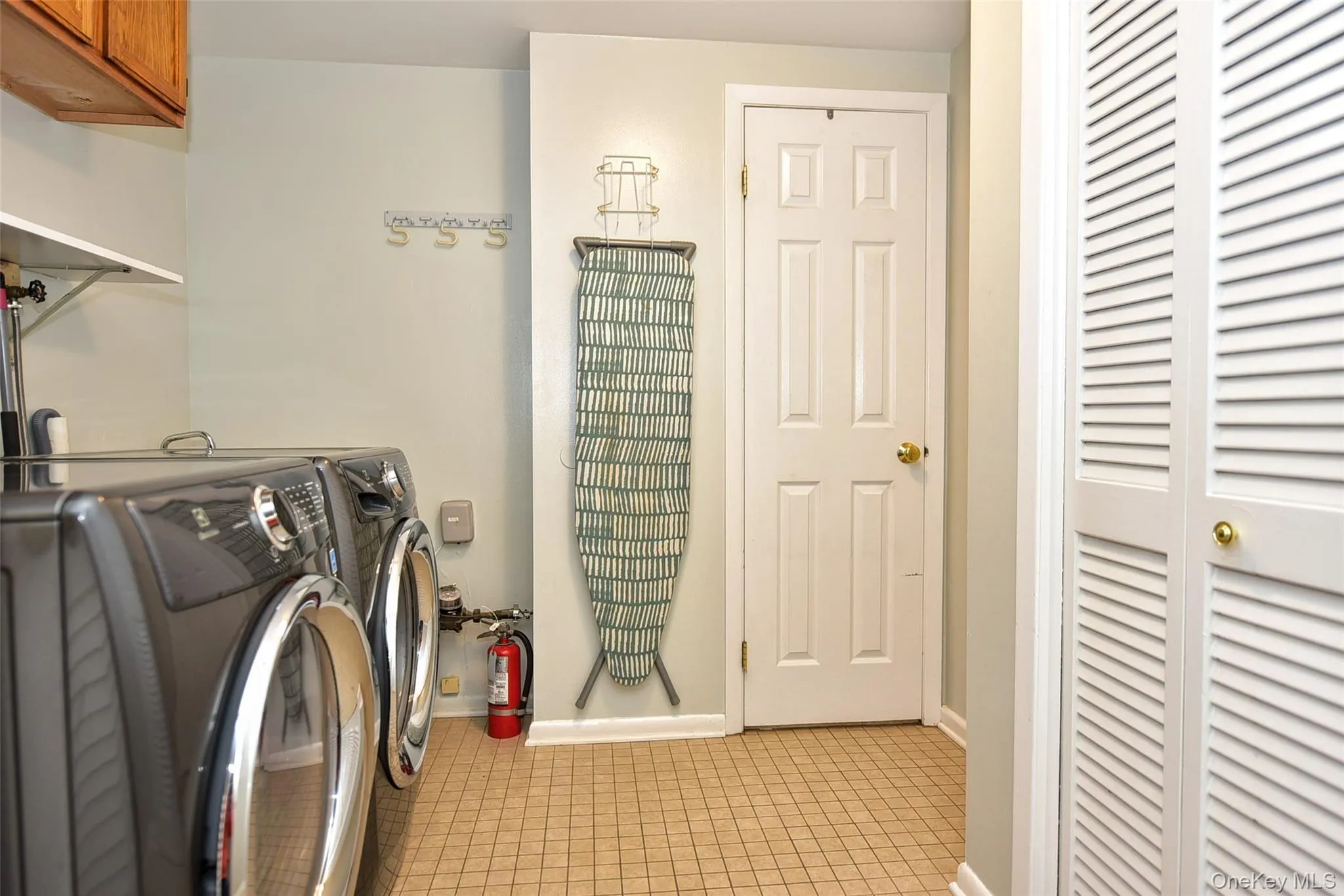 Laundry area with light tile patterned floors, washer and dryer, and cabinet space Laundry area with light tile patterned floors, washer and dryer, and cabinet space