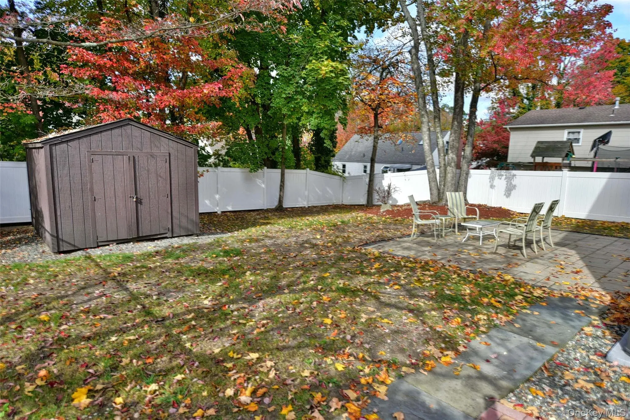 Fenced backyard with a patio area and a storage unit Fenced backyard with a patio area and a storage unit