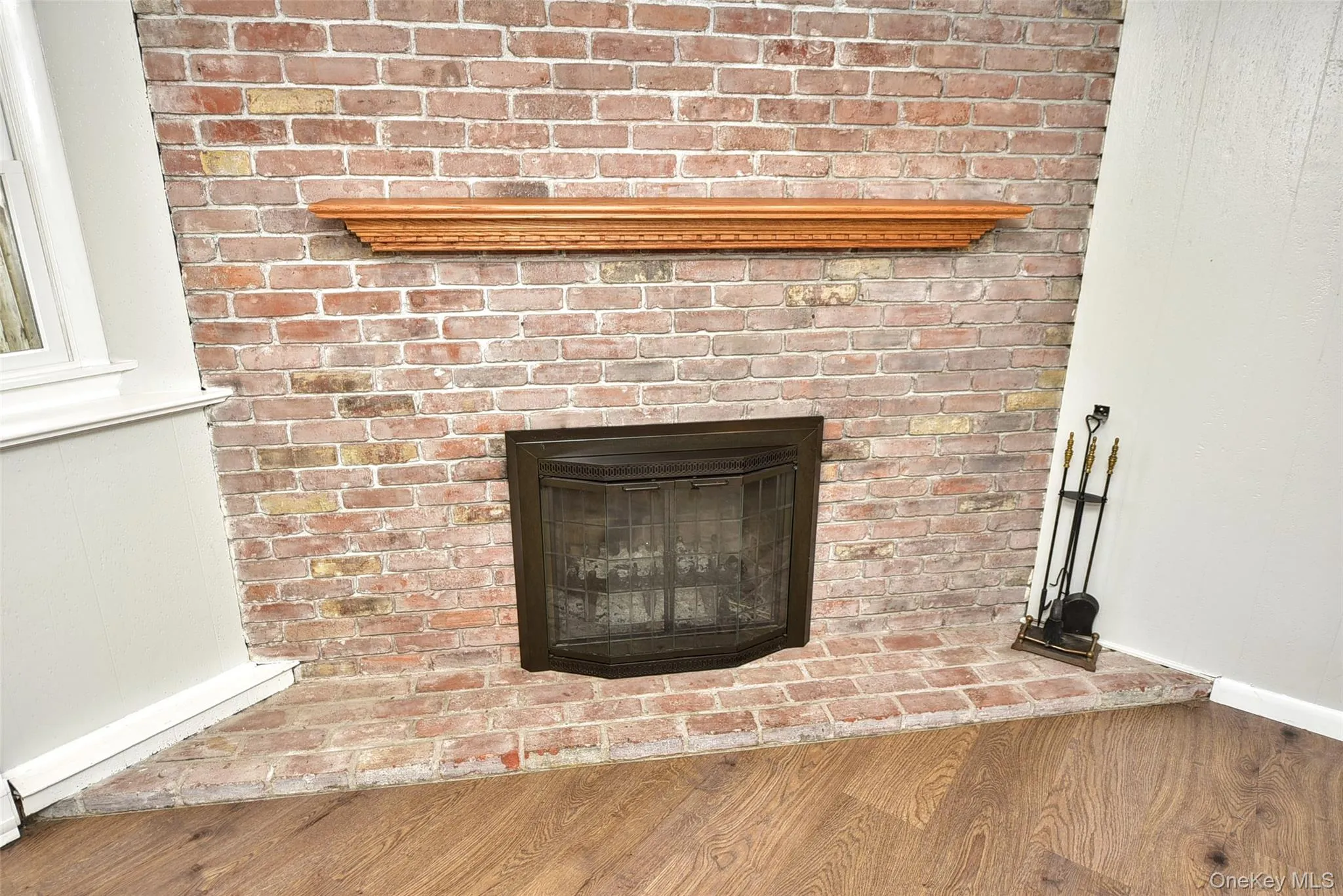 Detailed view of wood finished floors and a fireplace Detailed view of wood finished floors and a fireplace