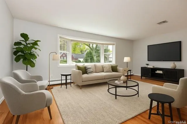 Staged - Living area featuring light wood-style flooring and baseboard heating Staged - Living area featuring light wood-style flooring and baseboard heating