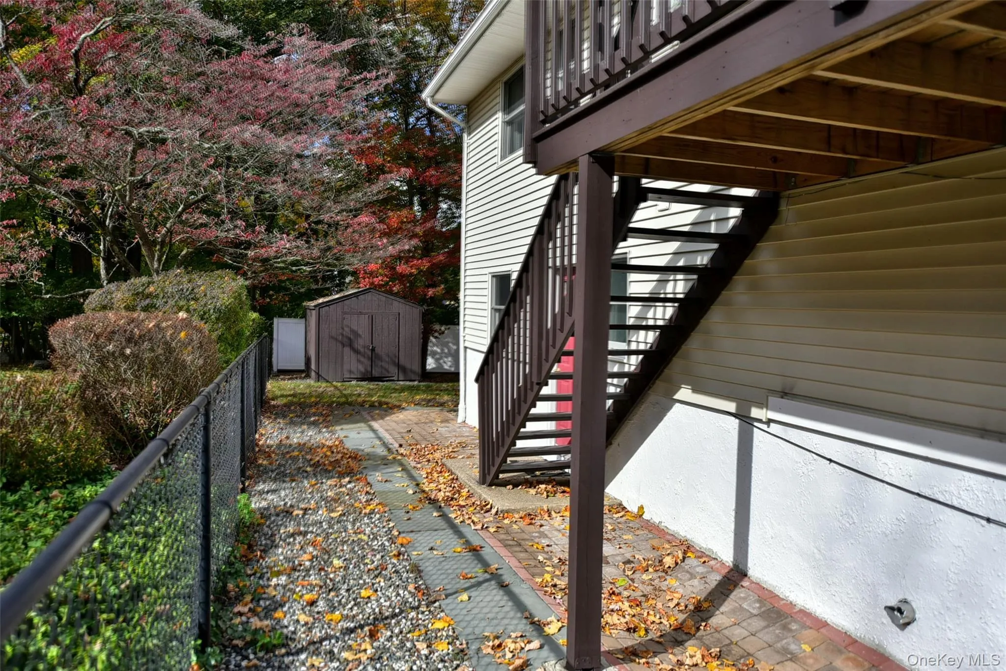 View of side of property featuring a storage unit and stairs View of side of property featuring a storage unit and stairs