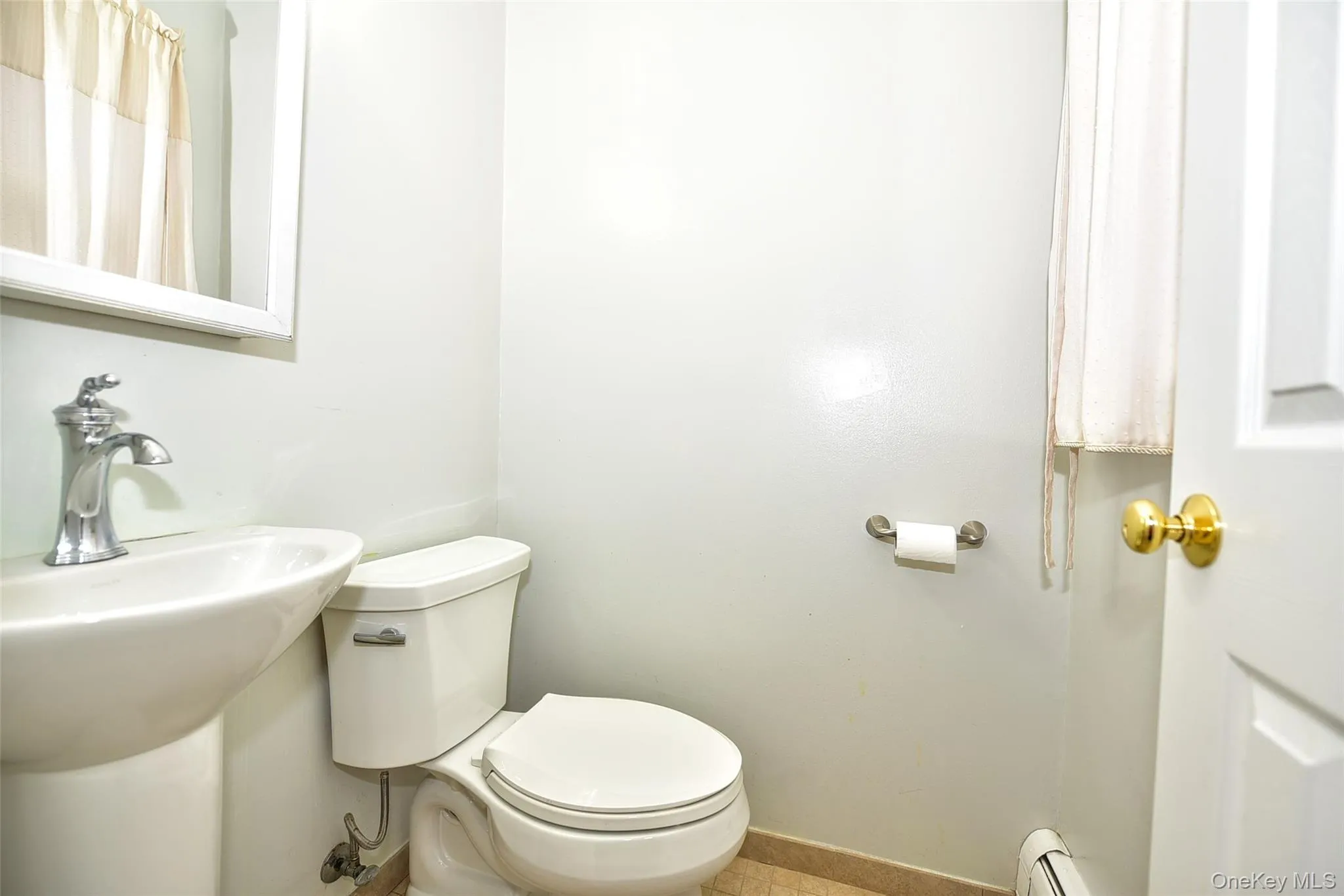 Bathroom featuring a baseboard heating unit and curtained shower Bathroom featuring a baseboard heating unit and curtained shower