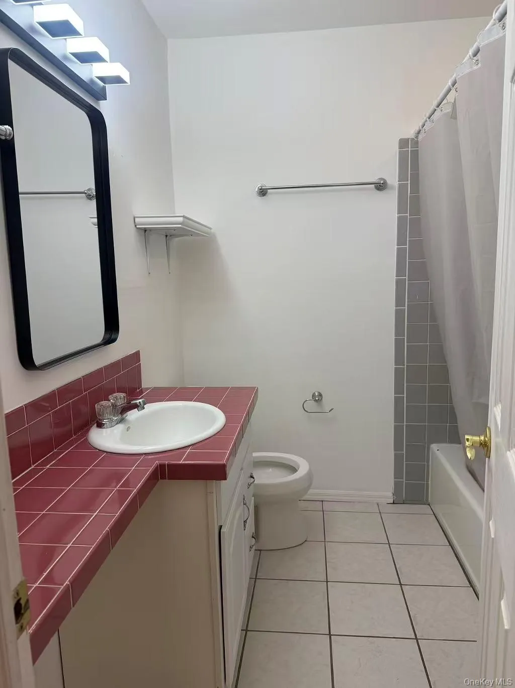 Full bath featuring vanity, shower / bath combo with shower curtain, and light tile patterned floors Full bath featuring vanity, shower / bath combo with shower curtain, and light tile patterned floors