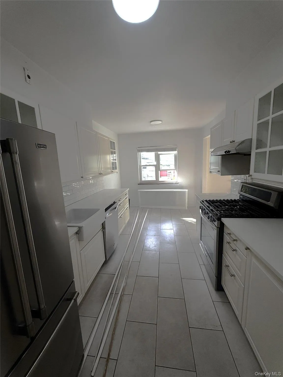 Kitchen featuring appliances with stainless steel finishes, white cabinets, and backsplash Kitchen featuring appliances with stainless steel finishes, white cabinets, and backsplash