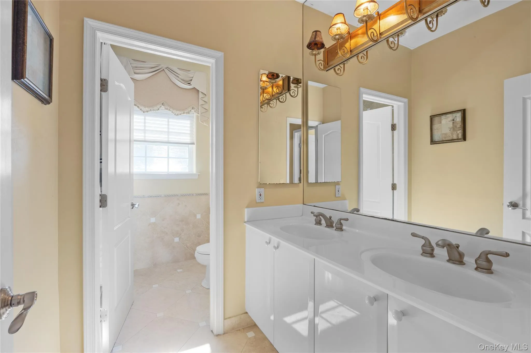 Bathroom with light tile patterned flooring, double vanity, and tile walls Bathroom with light tile patterned flooring, double vanity, and tile walls