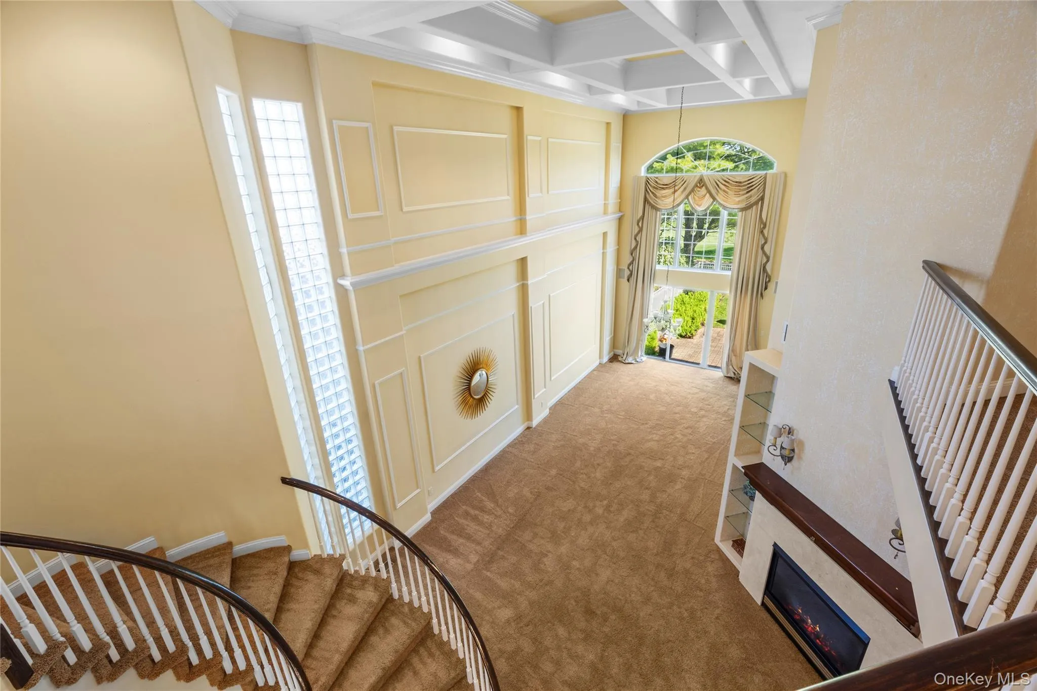Stairs featuring beamed ceiling, coffered ceiling, a towering ceiling, and carpet Stairs featuring beamed ceiling, coffered ceiling, a towering ceiling, and carpet