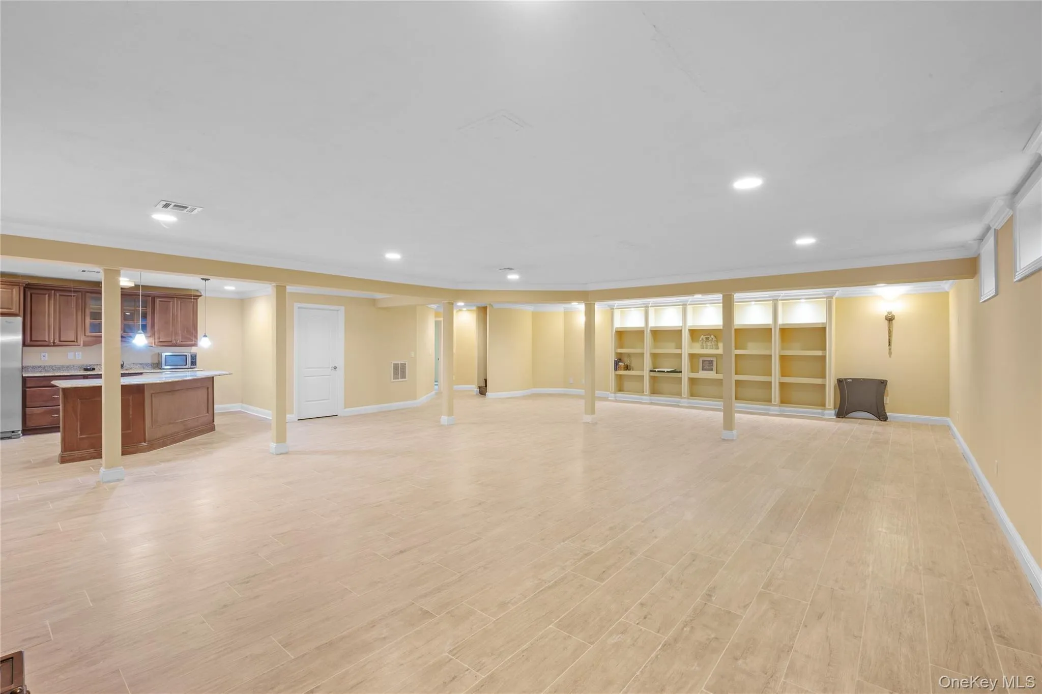 Unfurnished living room featuring ornamental molding, recessed lighting, and light wood-style flooring Unfurnished living room featuring ornamental molding, recessed lighting, and light wood-style flooring