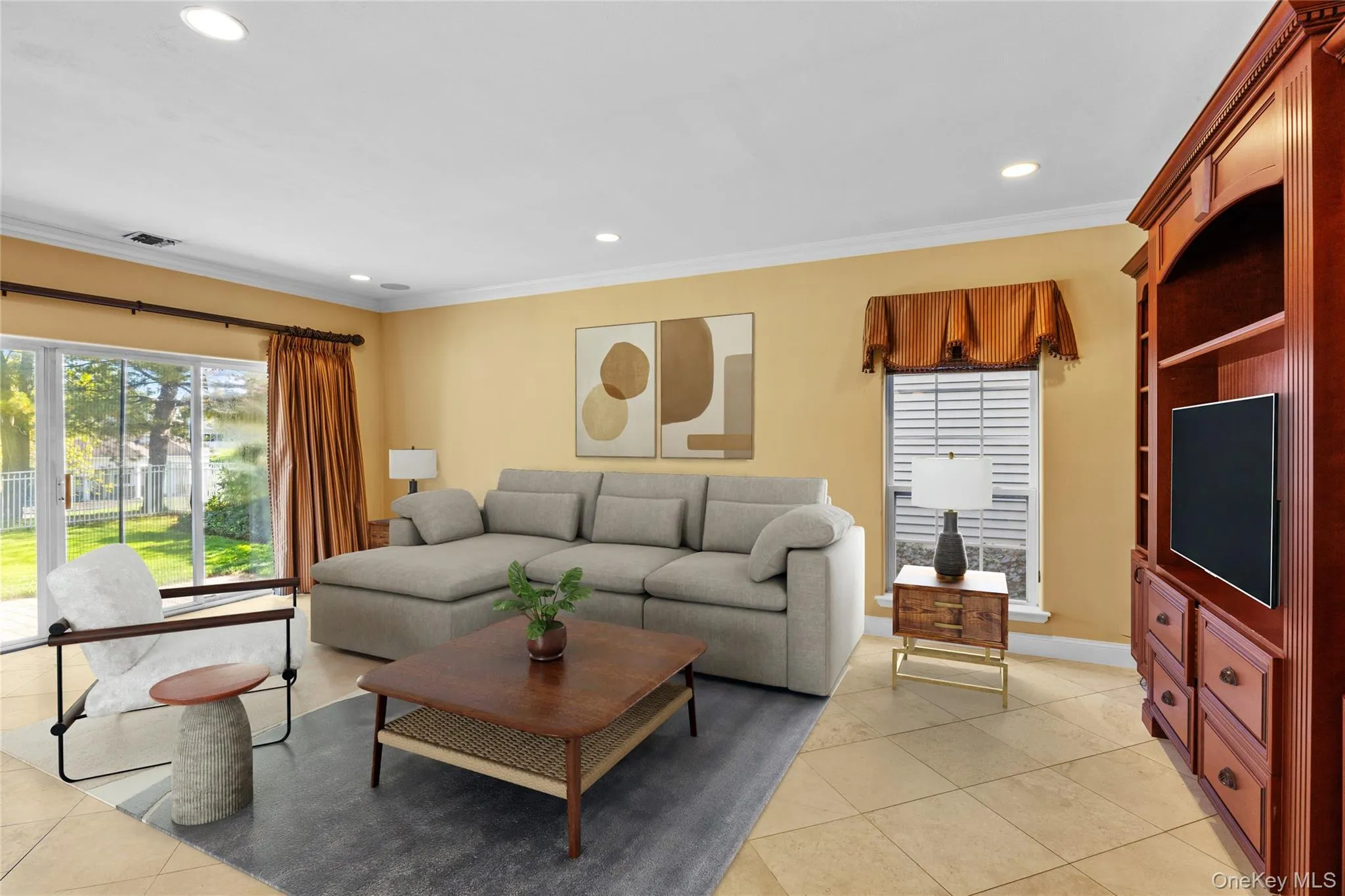 Living area featuring healthy amount of natural light, light tile patterned flooring, recessed lighting, and crown molding Living area featuring healthy amount of natural light, light tile patterned flooring, recessed lighting, and crown molding